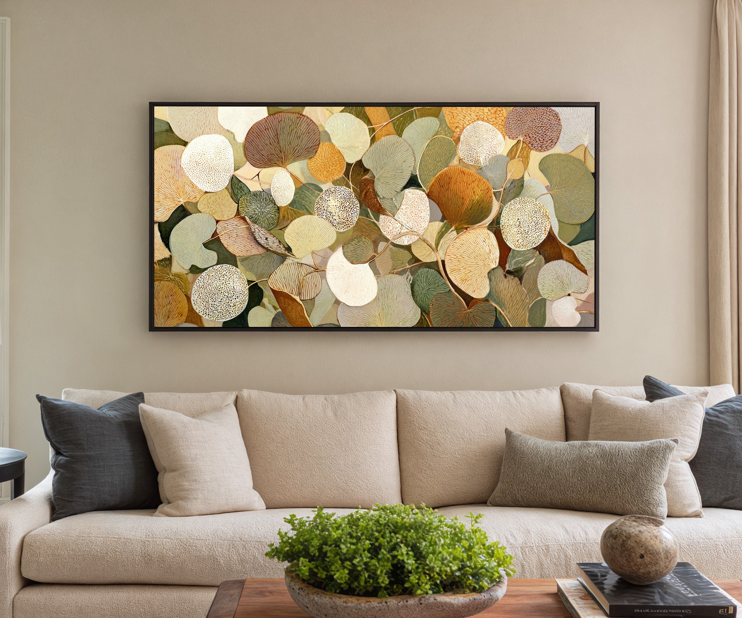 rounded leaf forms in olive, cream, gold, rust, canvas wall art in a black frame in a styled room setting