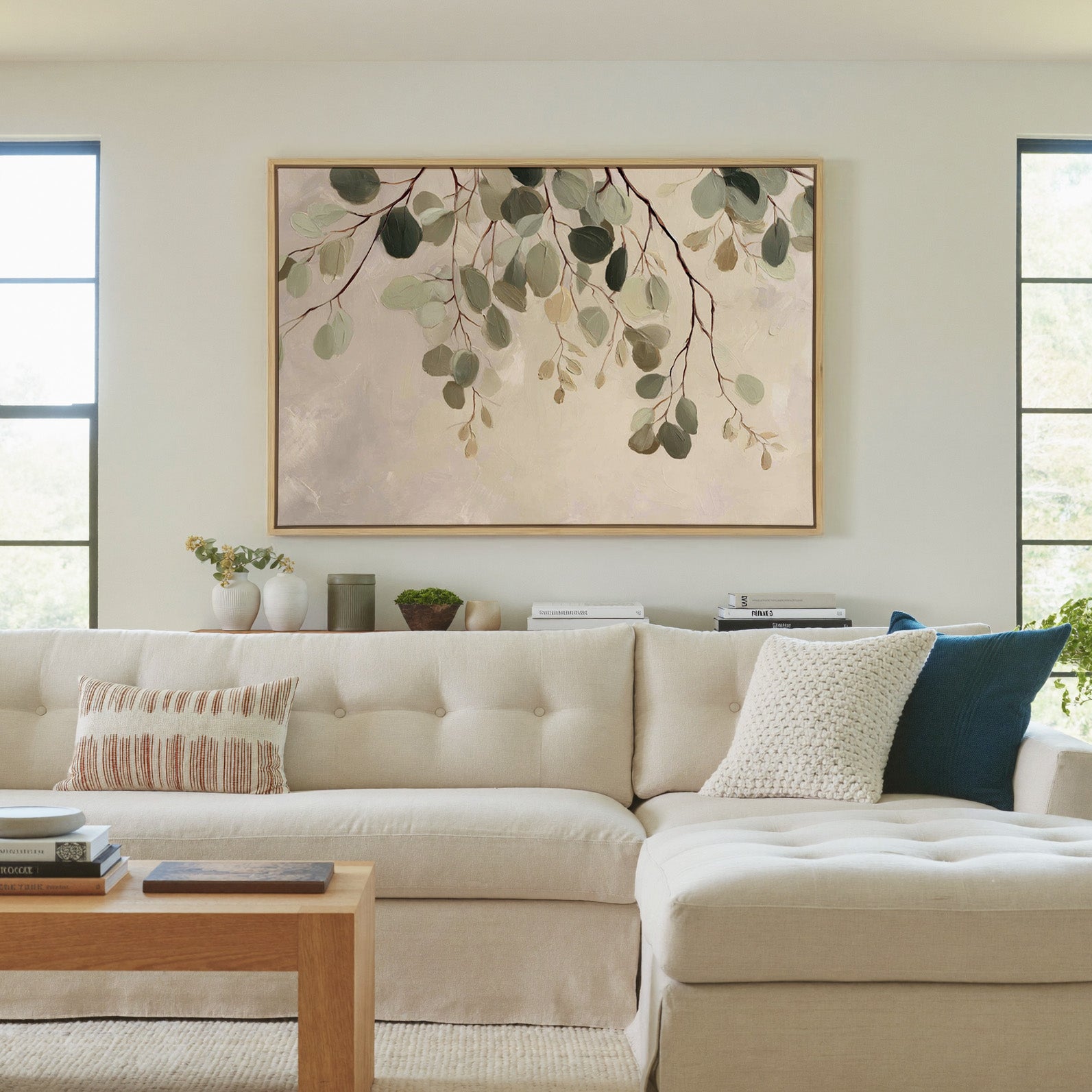 airy eucalyptus leaves on pale ground canvas wall art in a natural wood frame in a living room