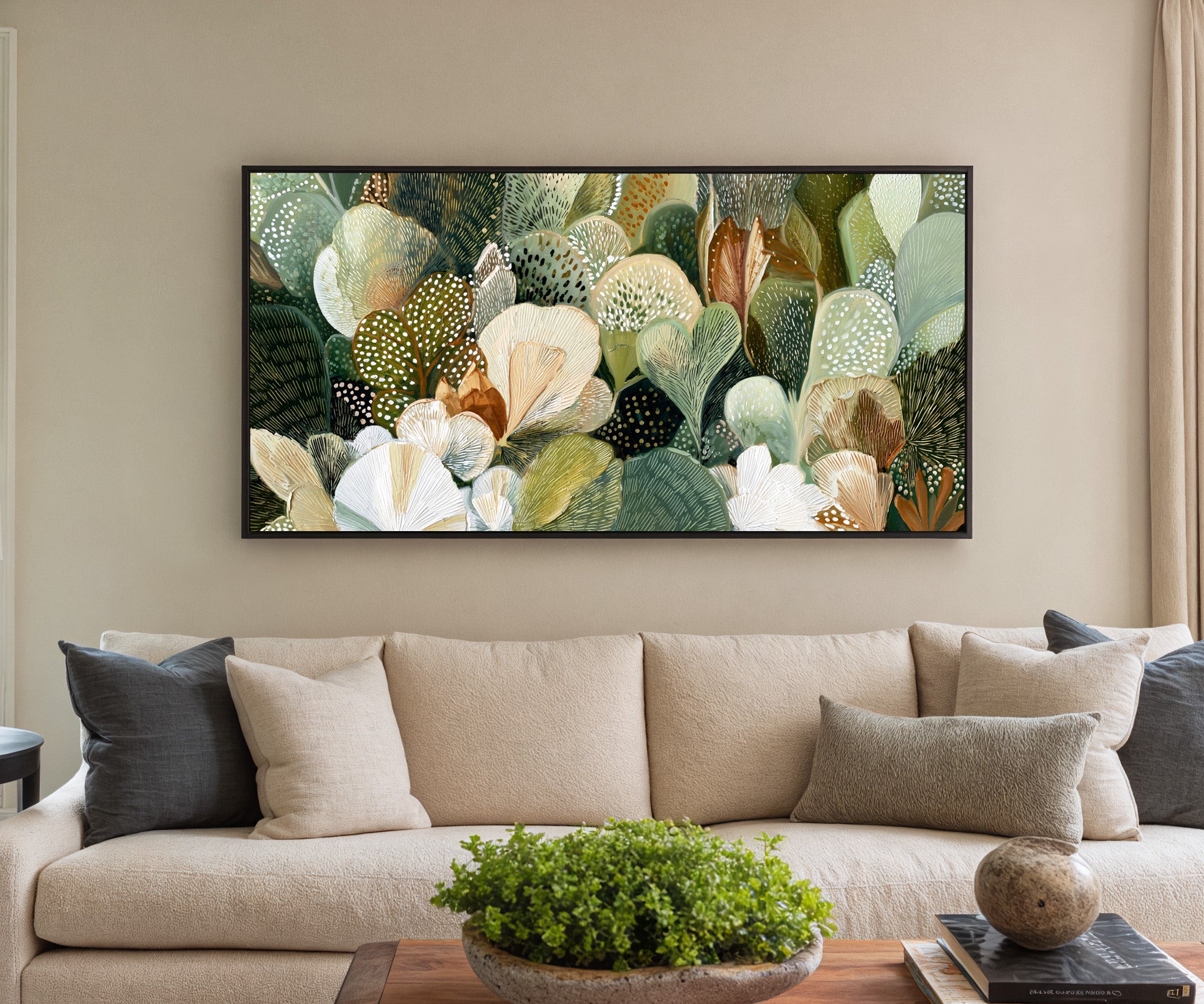 dense green and cream leaf forms canvas wall art in a black frame in a styled room setting