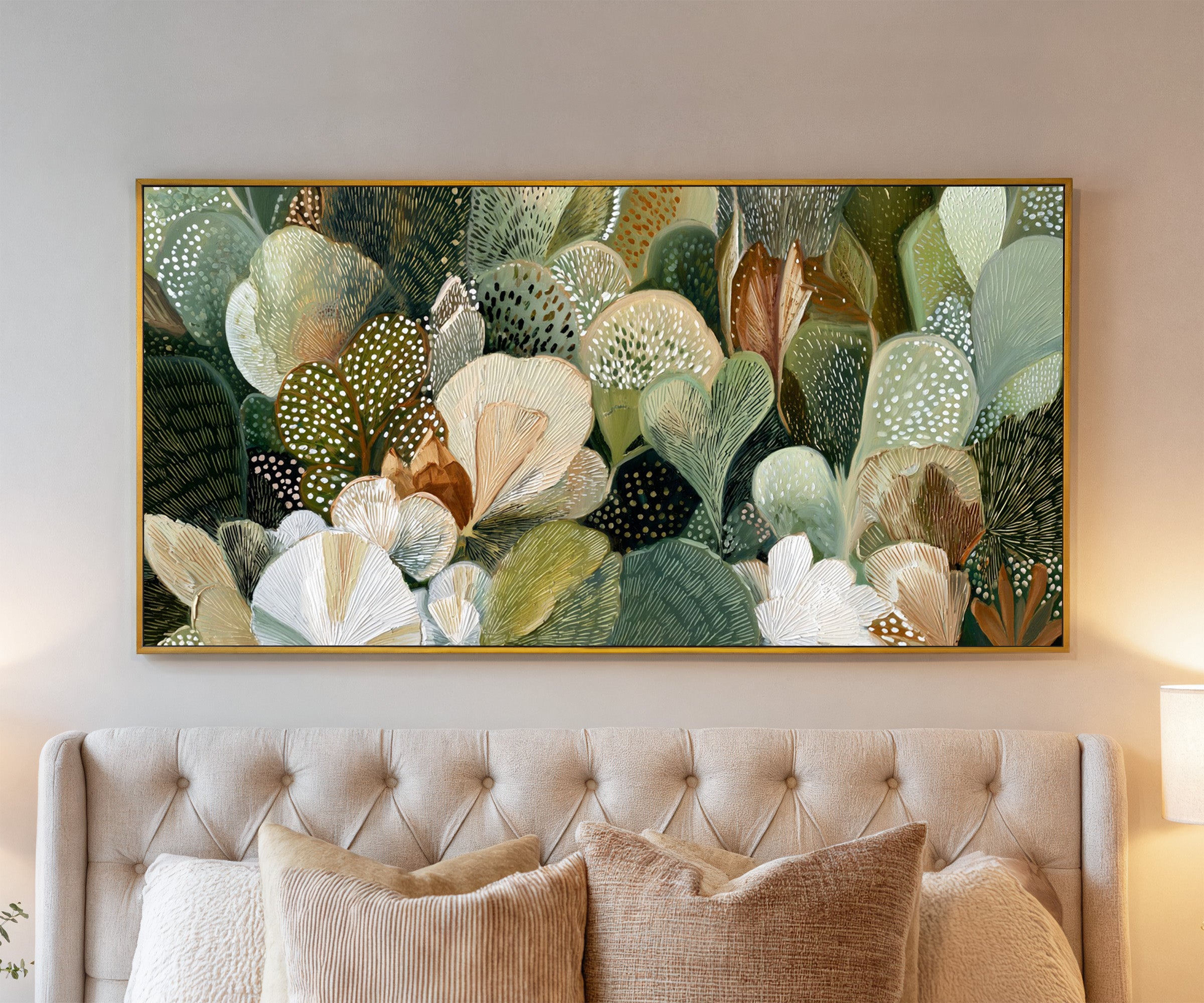 dense green and cream leaf forms canvas wall art in a gold frame above a bed