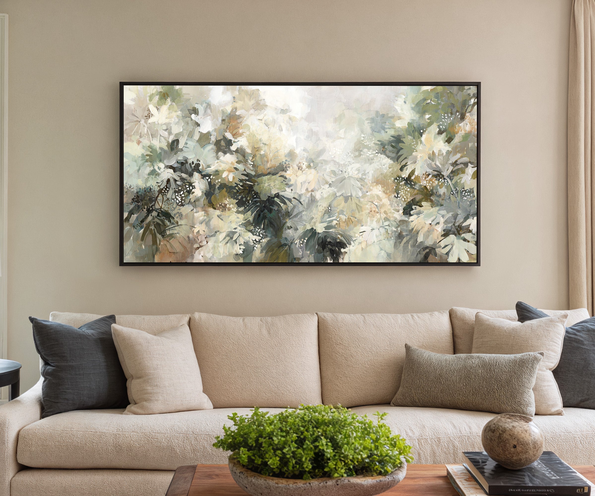 soft layered foliage in cream, sage, olive, and canvas wall art in a black frame in a styled room setting