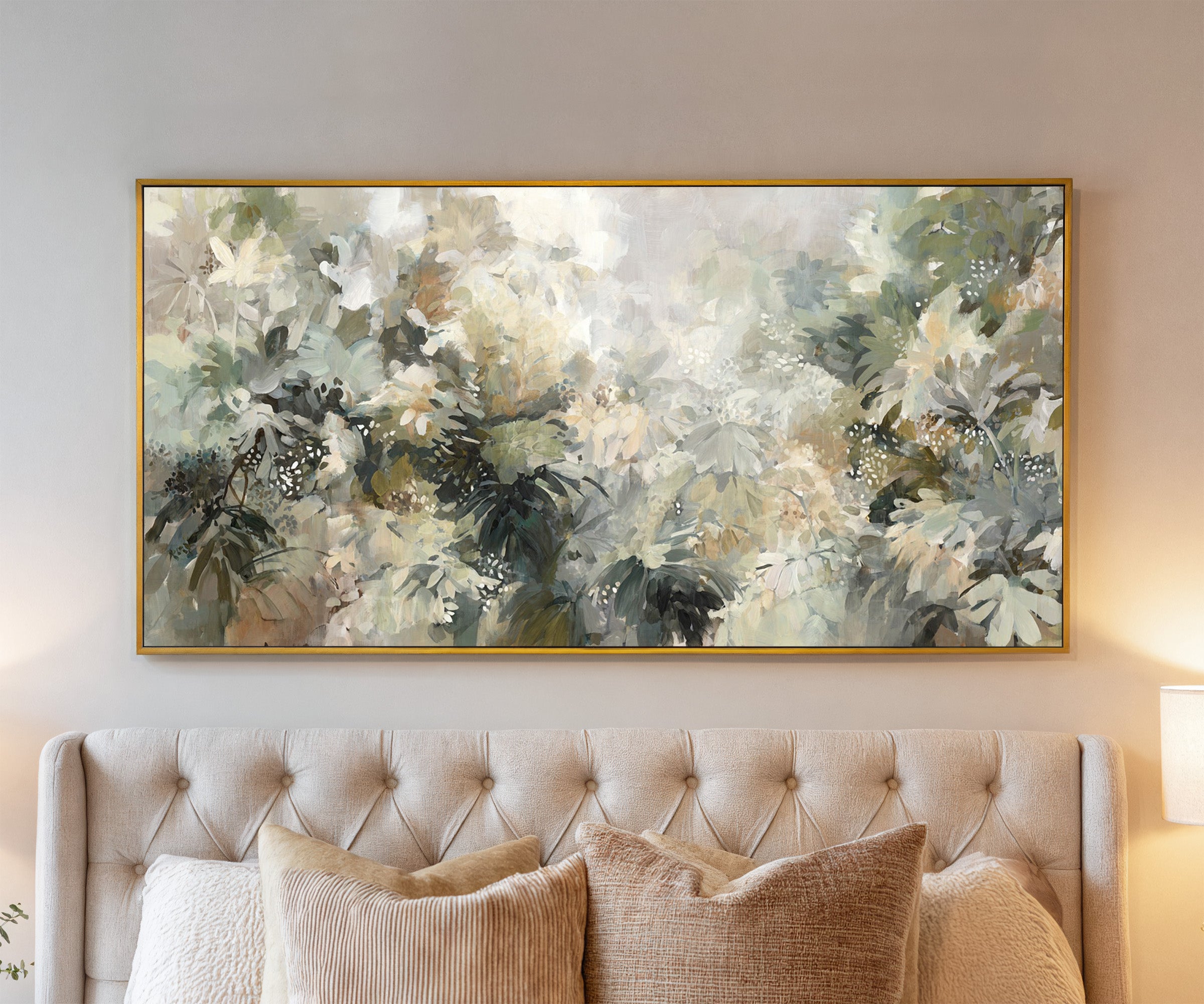 soft layered foliage in cream, sage, olive, and canvas wall art in a gold frame above a bed
