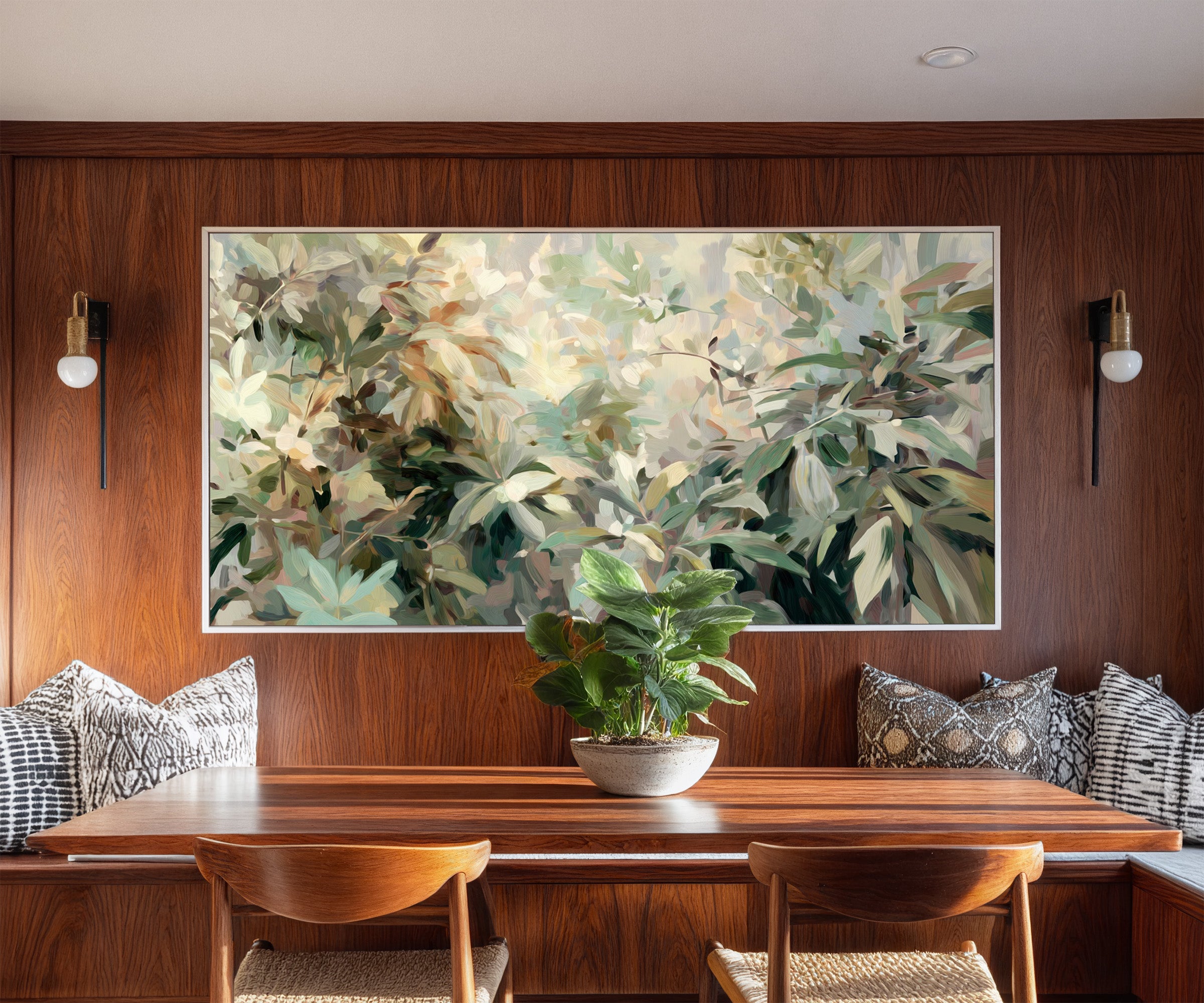 lush layered foliage in soft green, cream, and canvas wall art in a white frame in a styled room setting