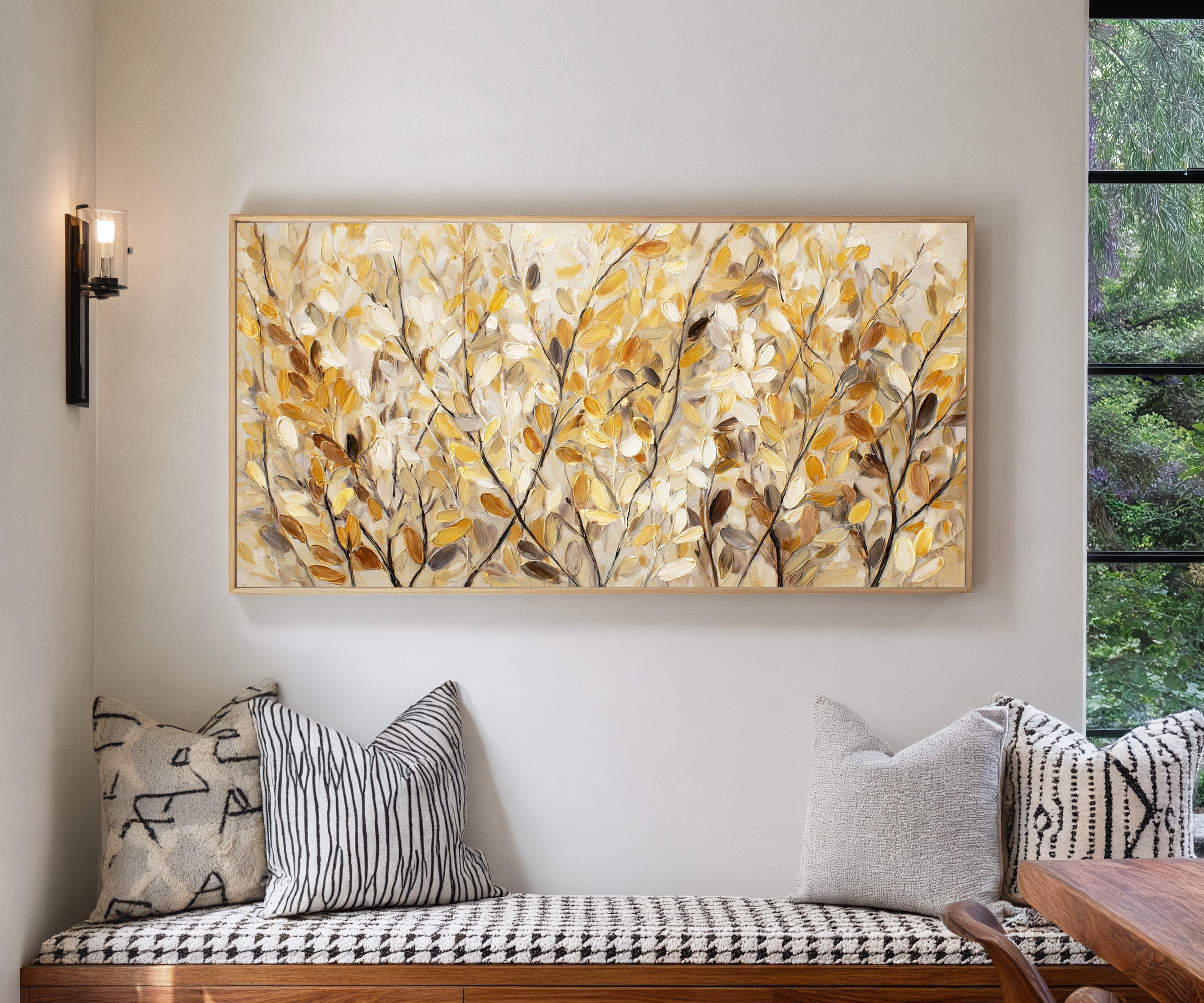 golden leaves and dark branching stems canvas wall art in a natural wood frame in a living room
