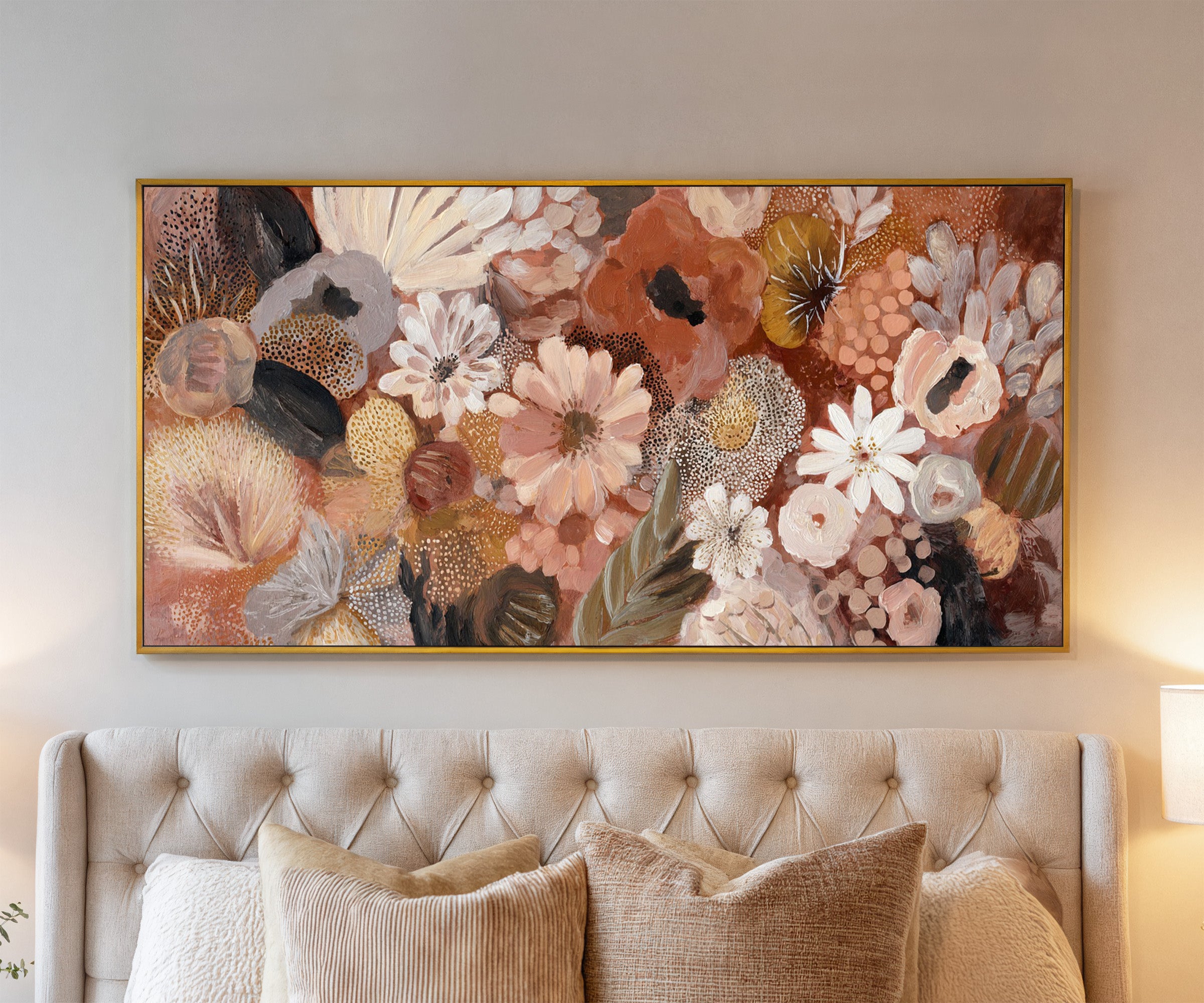 densely packed rounded florals in terracotta, canvas wall art in a gold frame above a bed