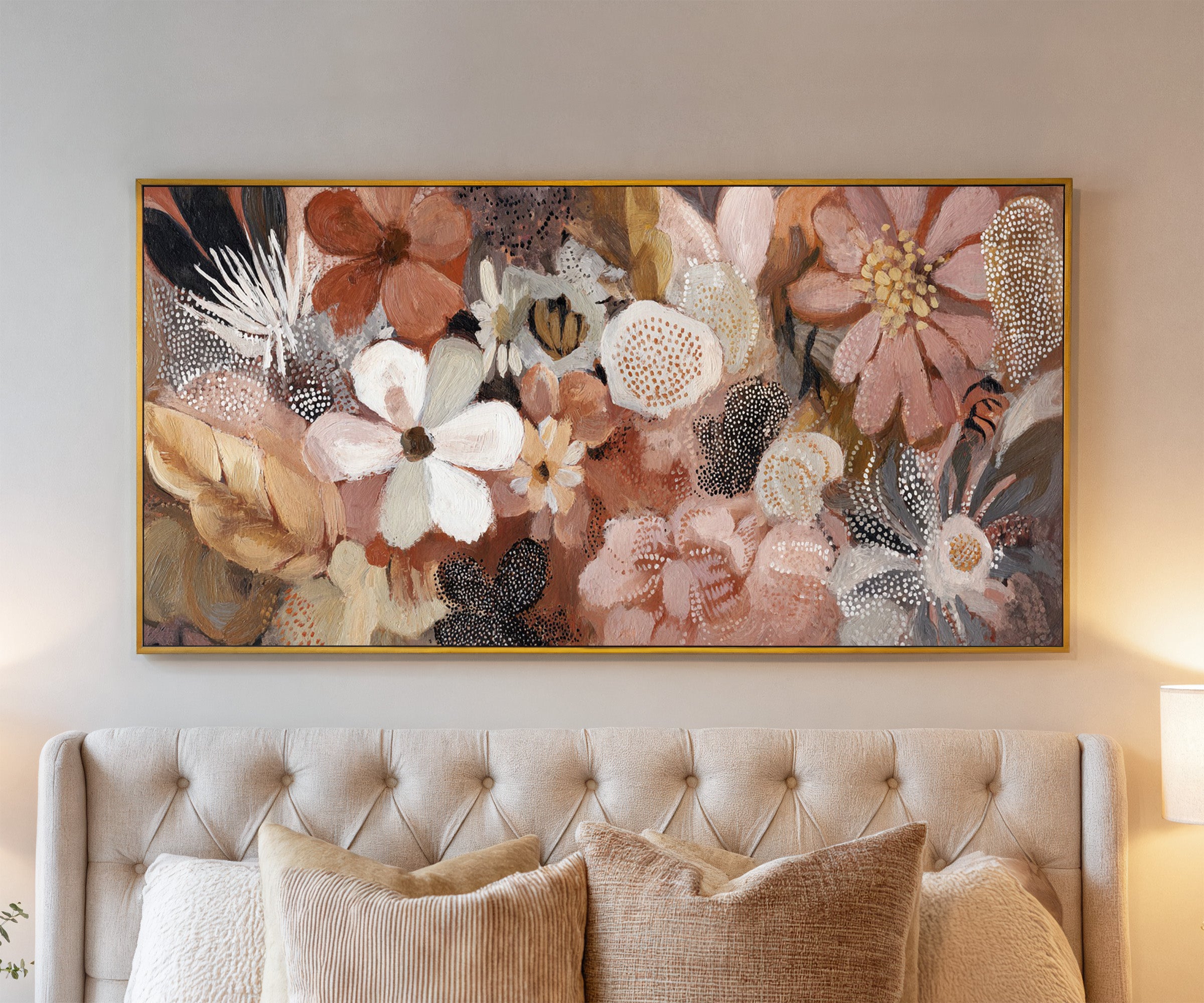 densely packed rounded flowers in blush, rust, canvas wall art in a gold frame above a bed