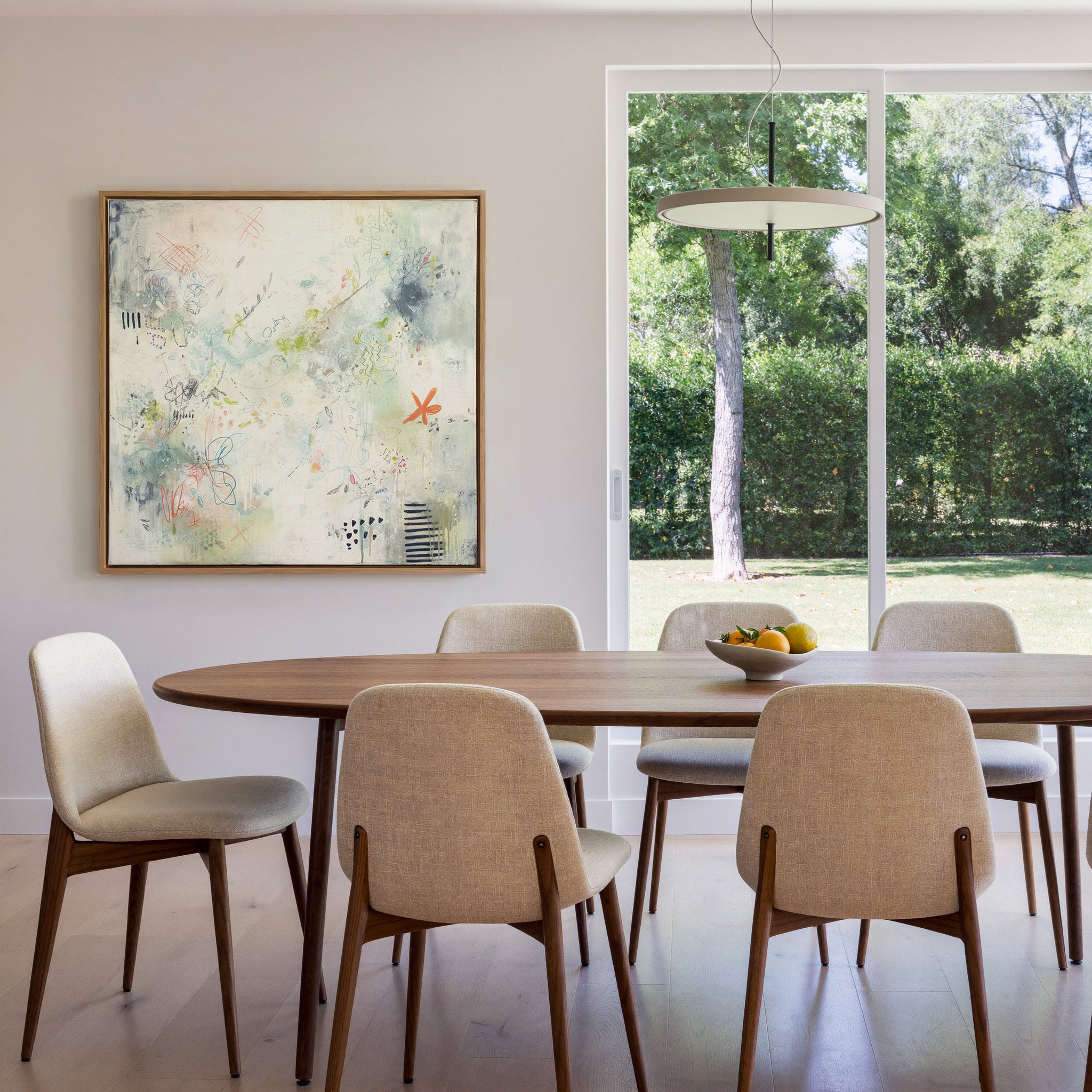 airy cream abstract with pastel doodles and canvas wall art in an oak frame in a dining room
