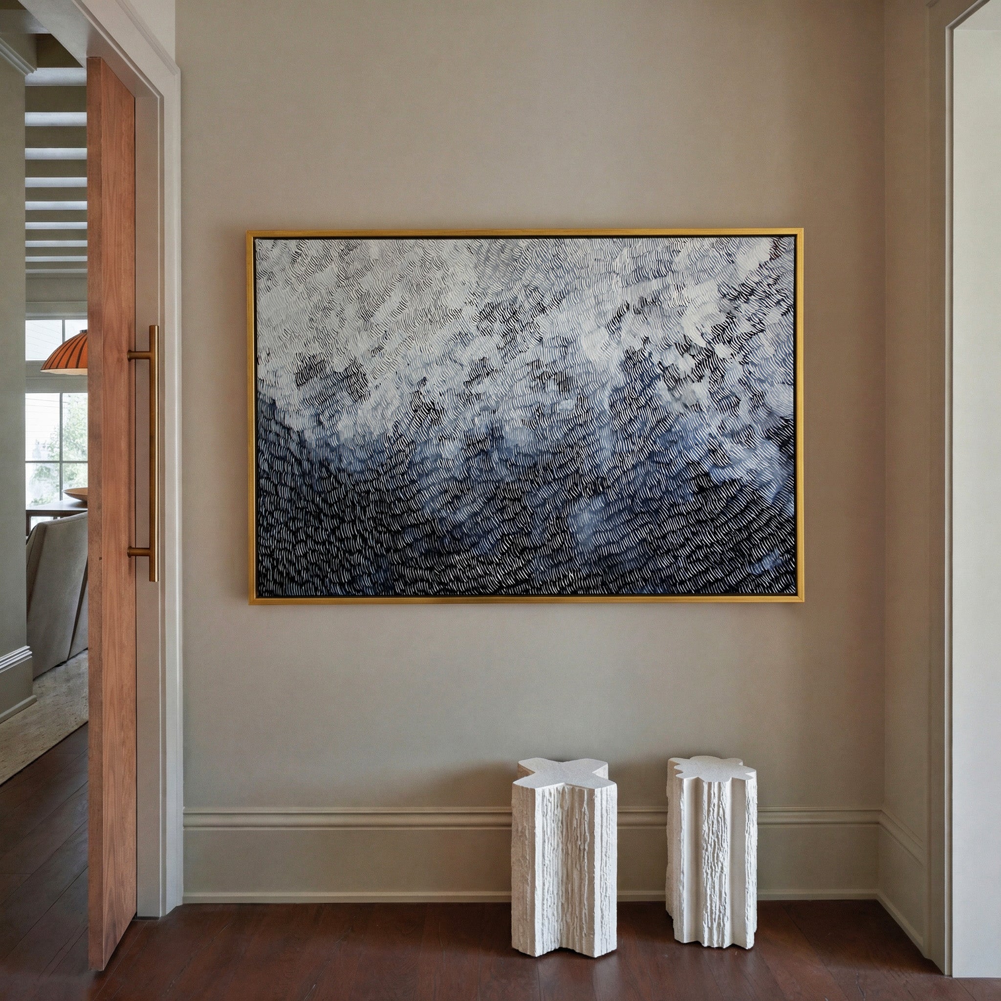 black and white abstract with dense curved canvas wall art in a gold frame in a styled room setting
