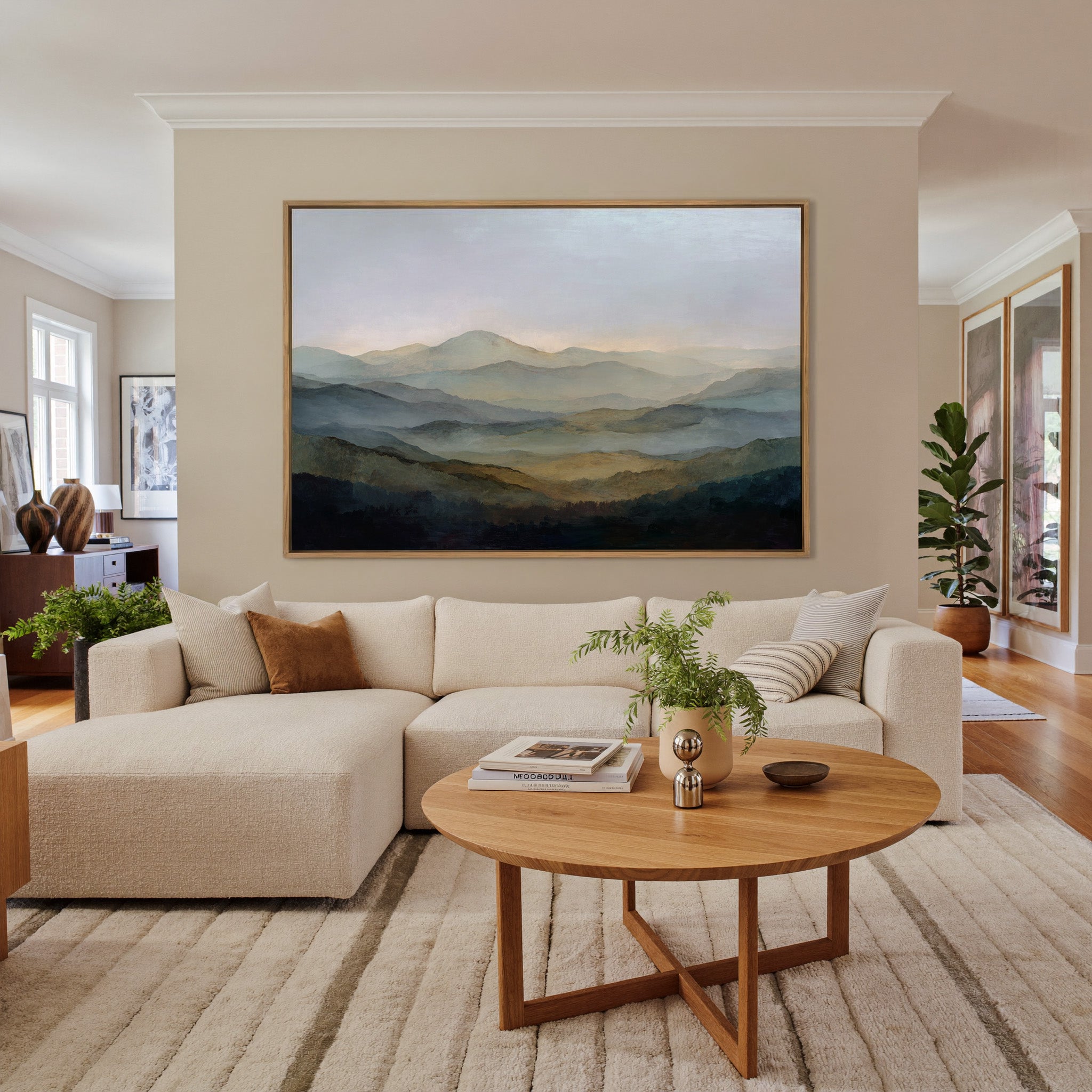 misty layered mountain landscape canvas wall art in an oak frame in a living room
