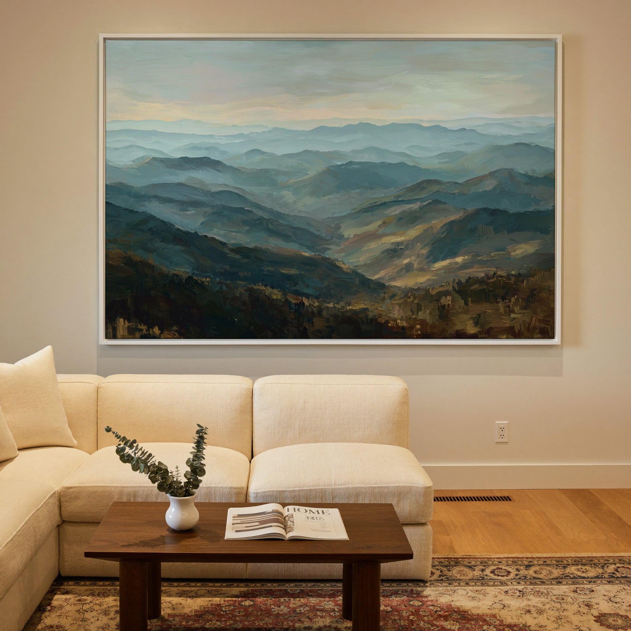layered blue ridgelines with pale sky and warm canvas wall art in a white frame in a styled room setting