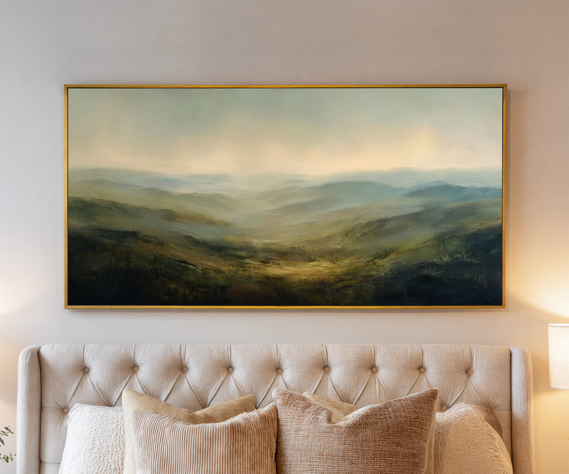 soft blue green ridgelines with a bright canvas wall art in a gold frame above a bed