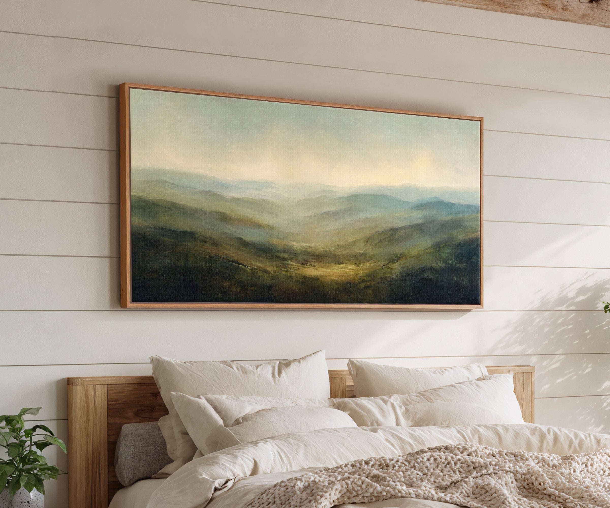 soft blue green ridgelines with a bright canvas wall art in an oak frame above a bed