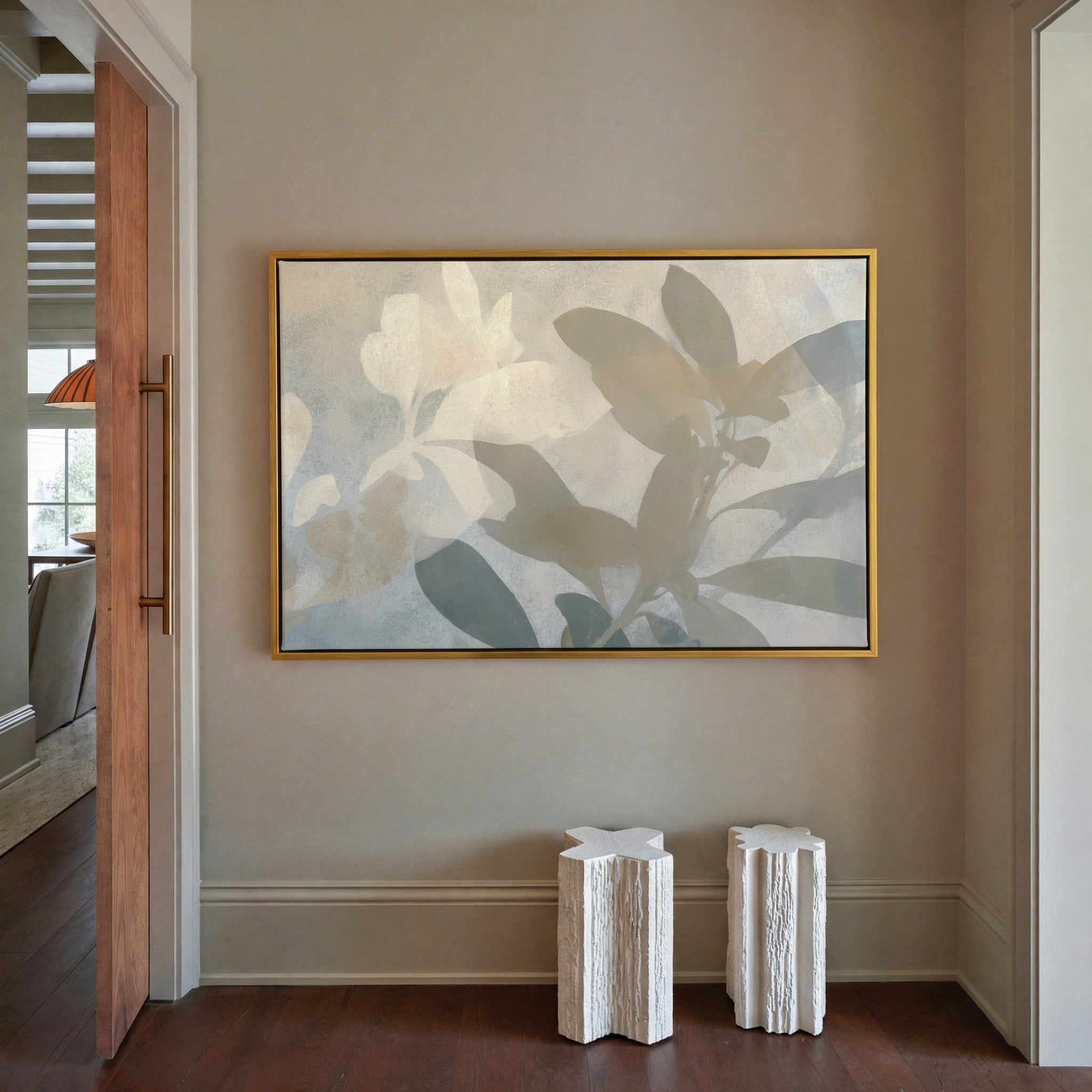 soft beige and gray leaf branch abstract canvas wall art in a gold frame in a styled room setting