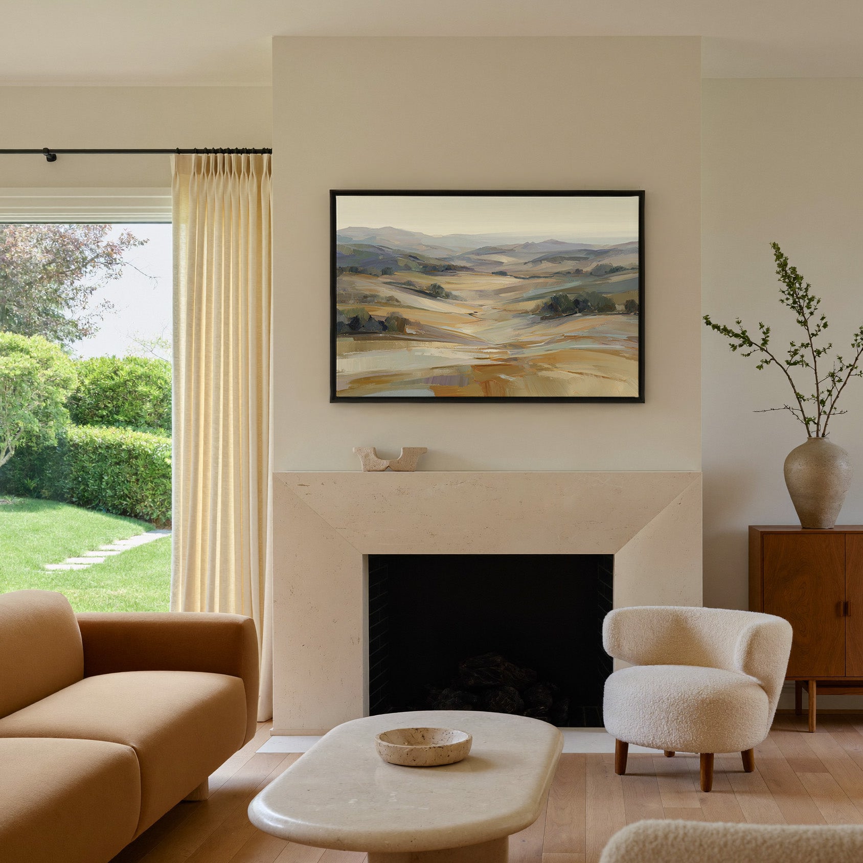 pale rolling hills and valley in cream, gold, canvas wall art in a black frame above a mantel