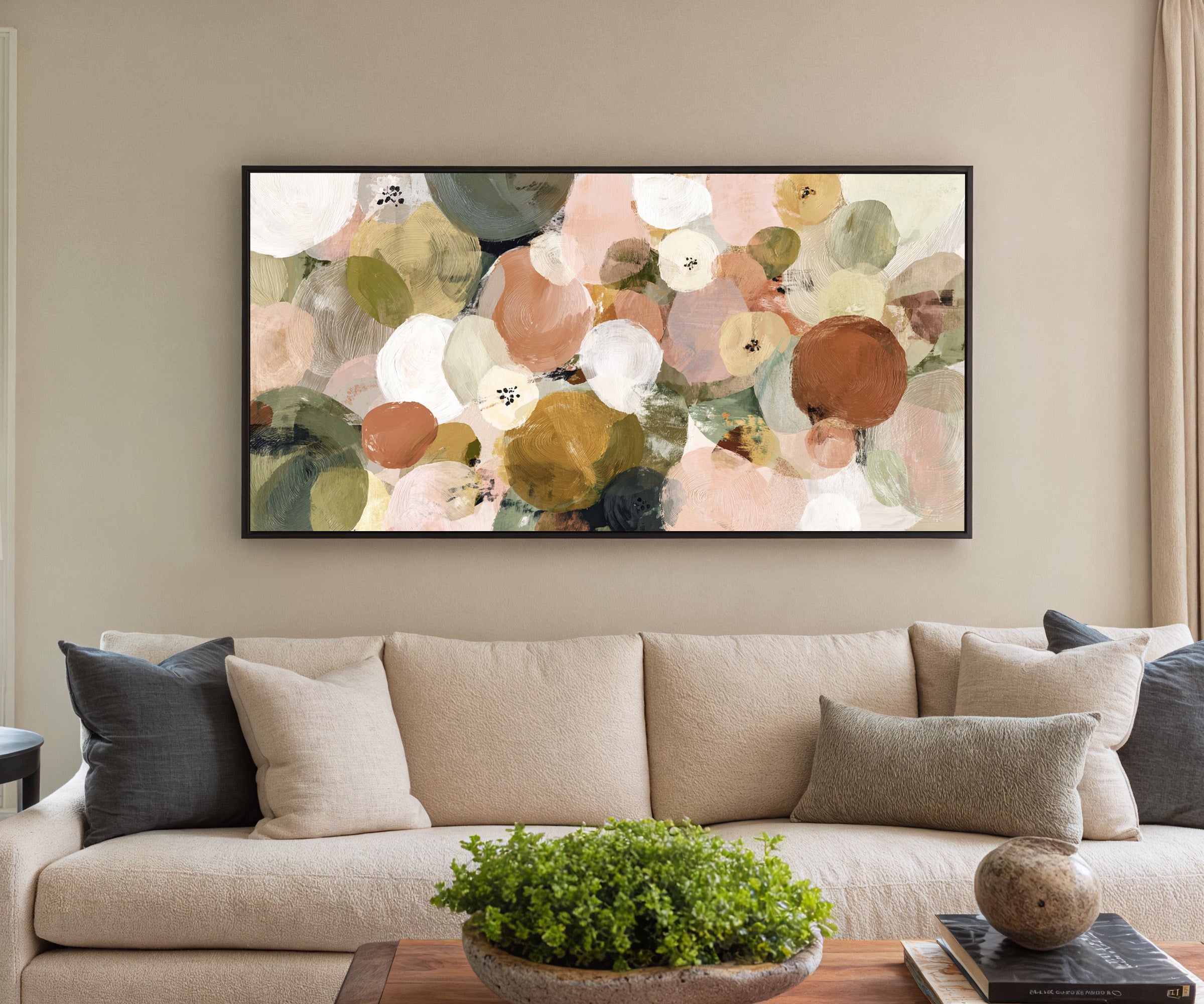 muted olive, blush, cream, and gold circles canvas wall art in a black frame in a styled room setting