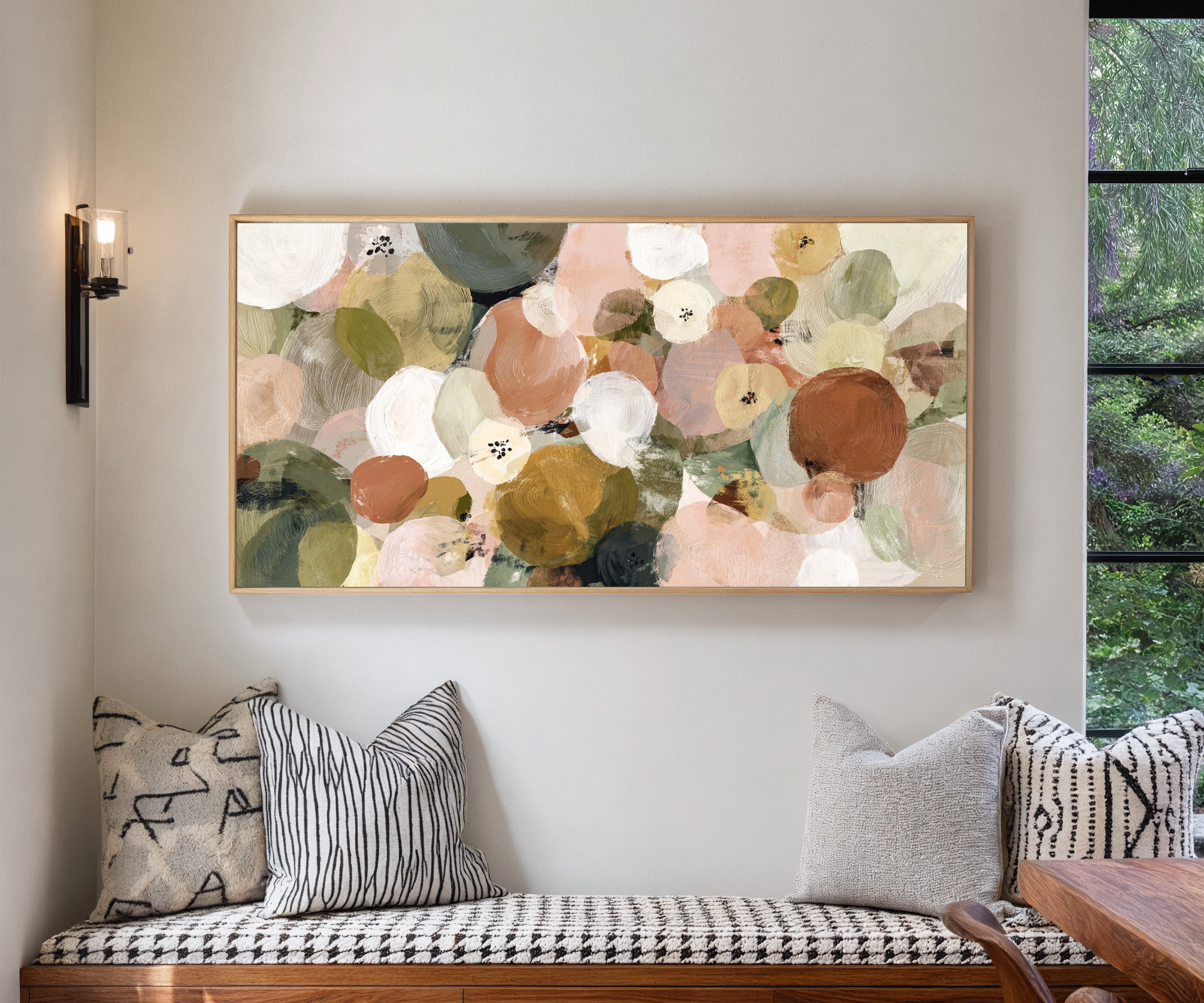 muted olive, blush, cream, and gold circles canvas wall art in a natural wood frame in a living room