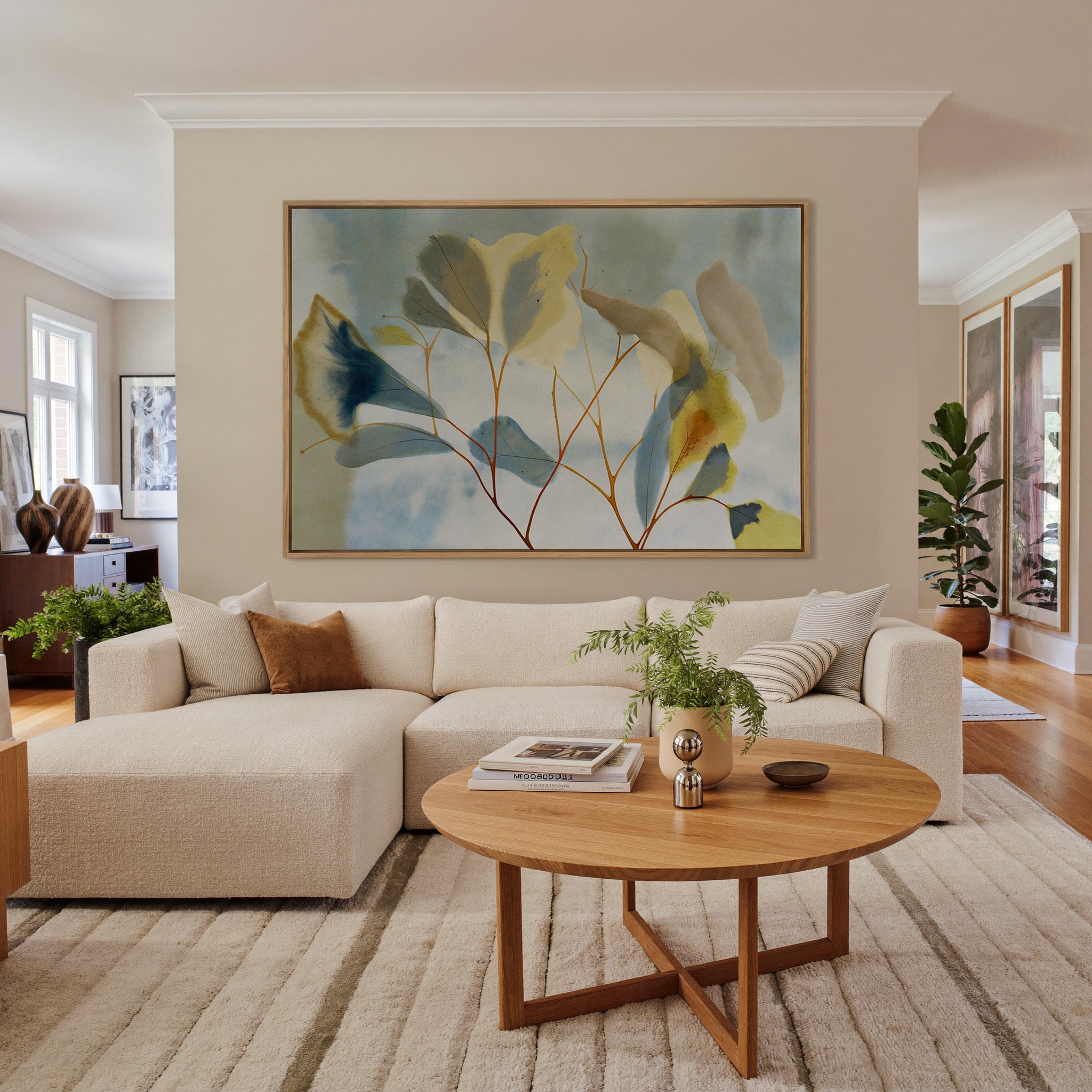 blue, cream, and yellow leaf branch canvas wall art in an oak frame in a living room