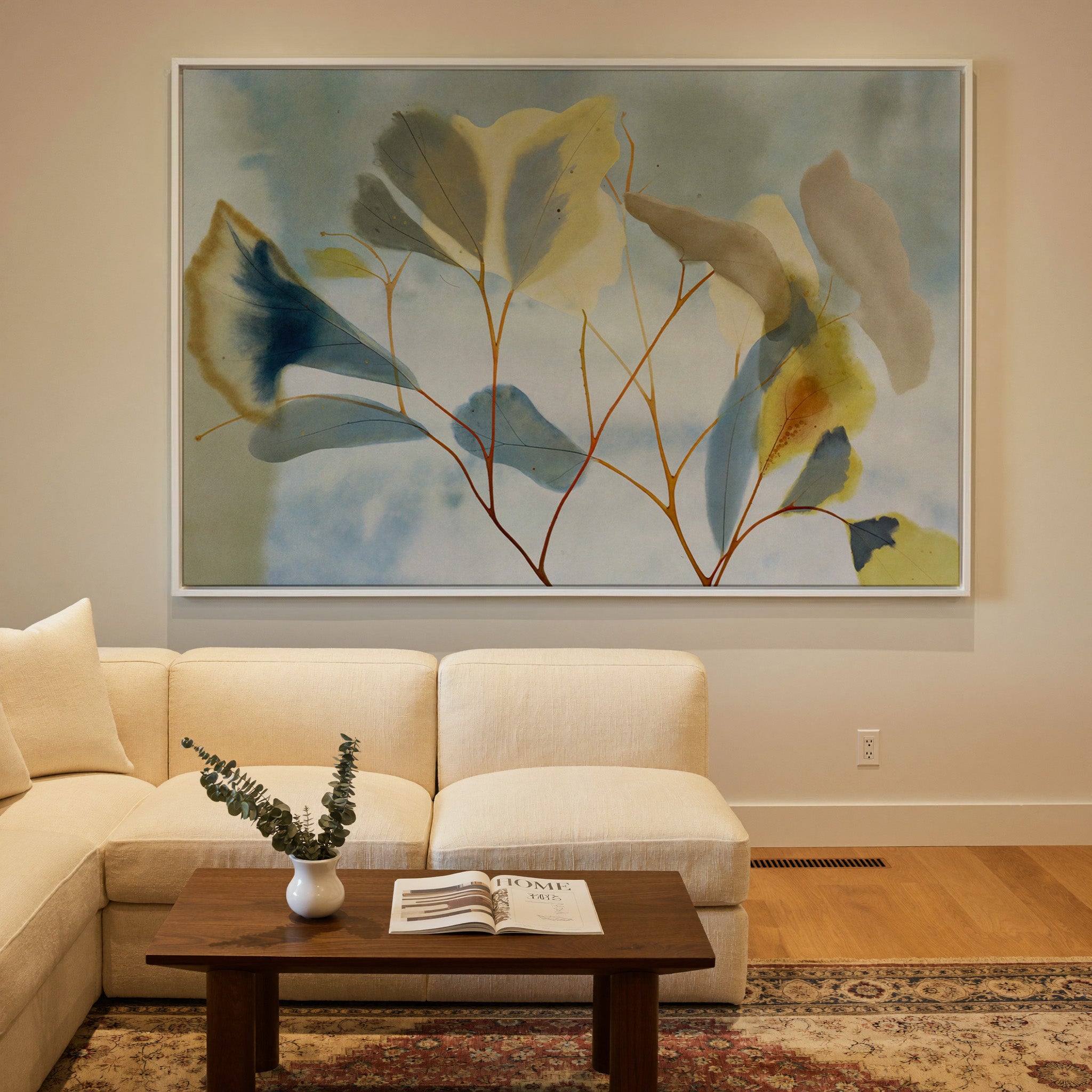 blue, cream, and yellow leaf branch canvas wall art in a white frame in a styled room setting