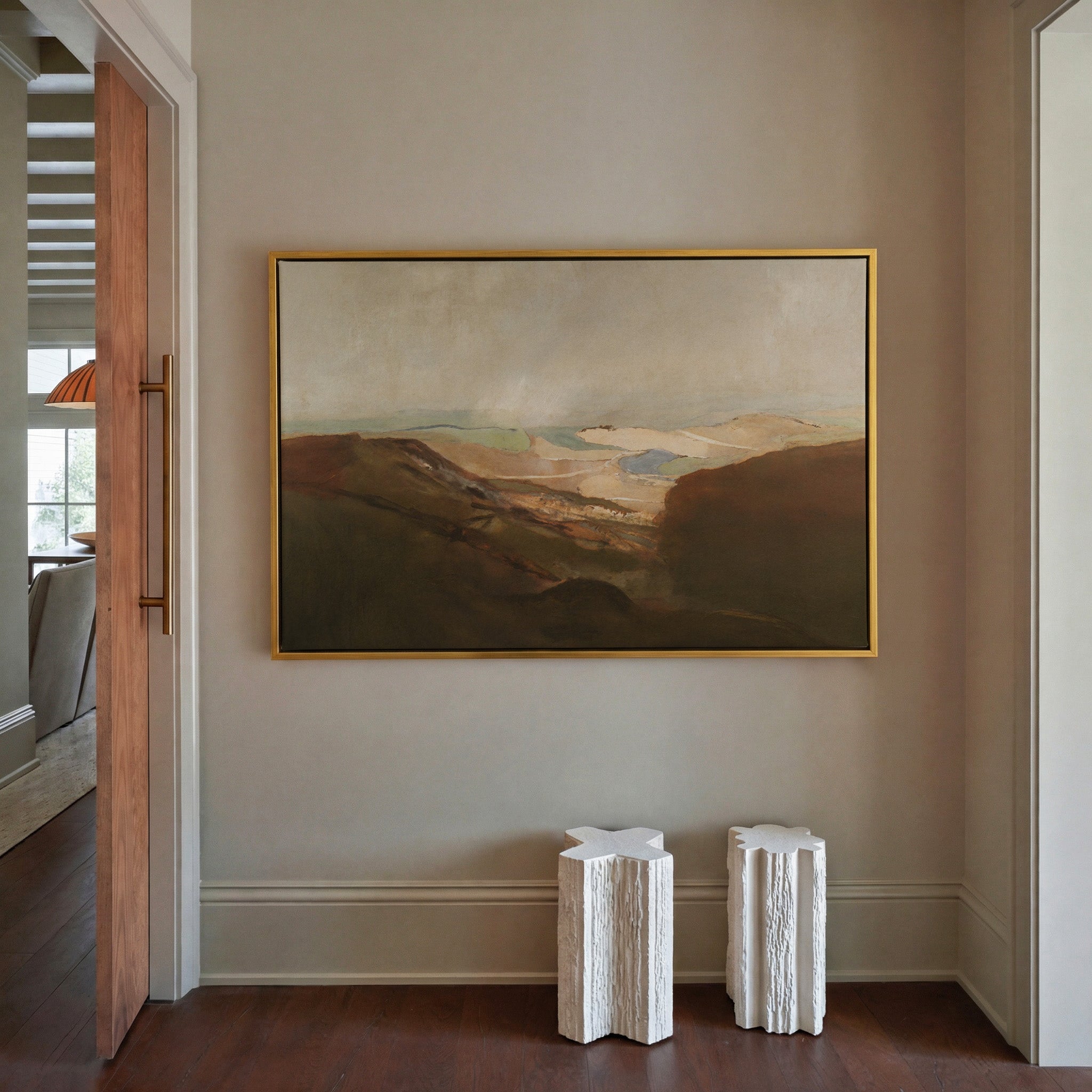 soft desert landscape with layered dunes and a canvas wall art in a gold frame in a styled room setting