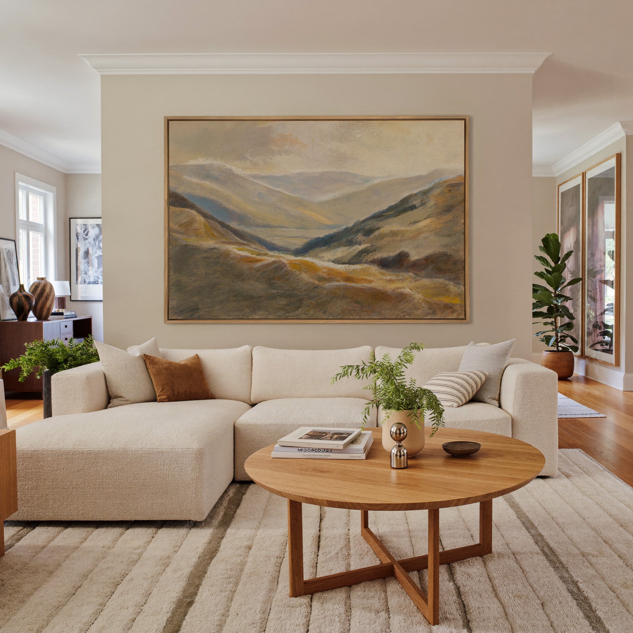 soft beige and blue mountain landscape canvas wall art in an oak frame in a living room
