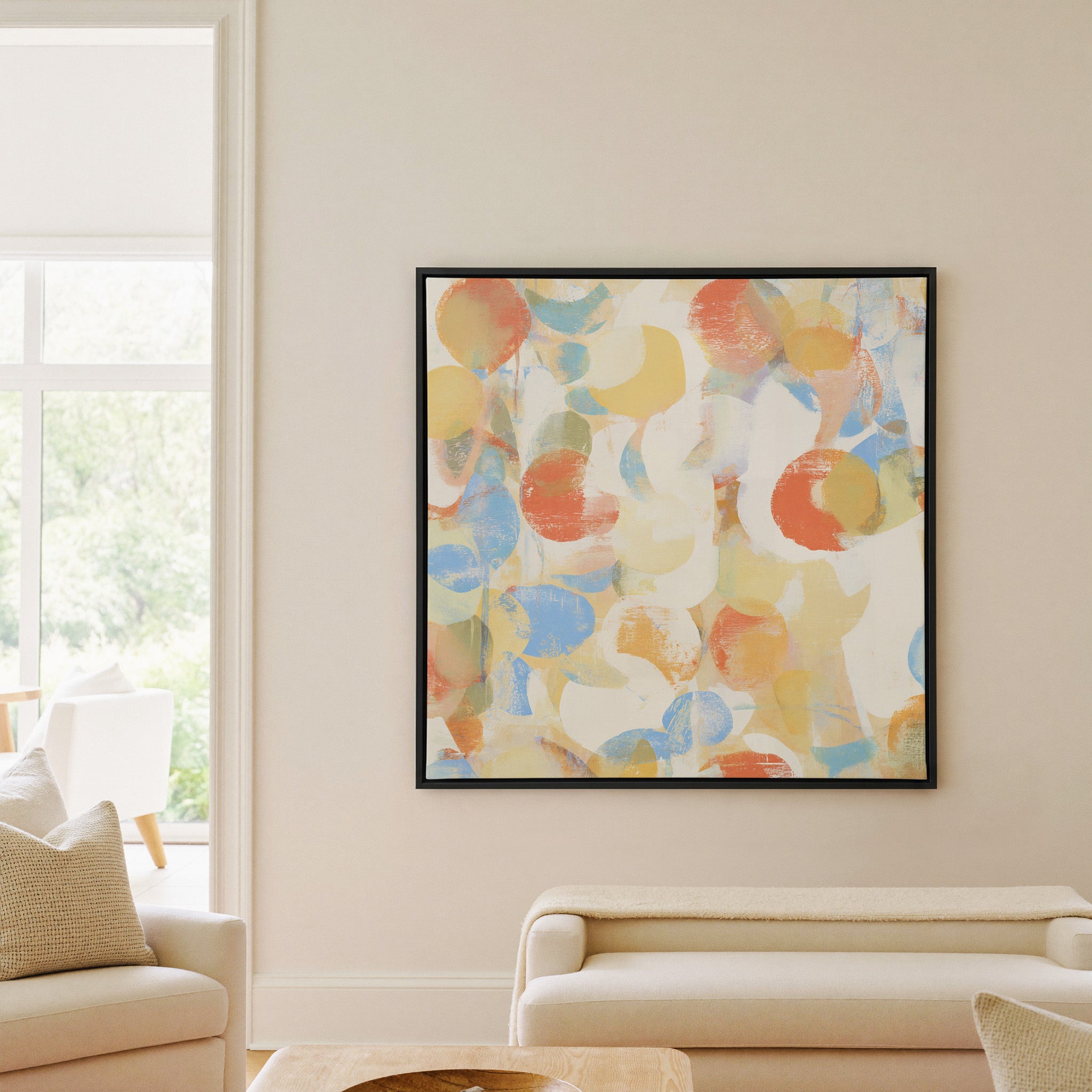 soft pastel circle abstract canvas wall art in a black frame in a living room