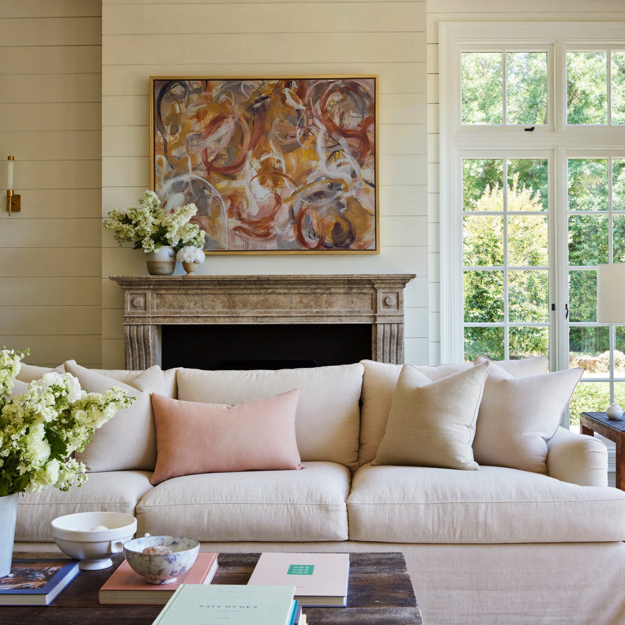 warm rust, gold, cream, and gray abstract with canvas wall art in a gold frame above a mantel