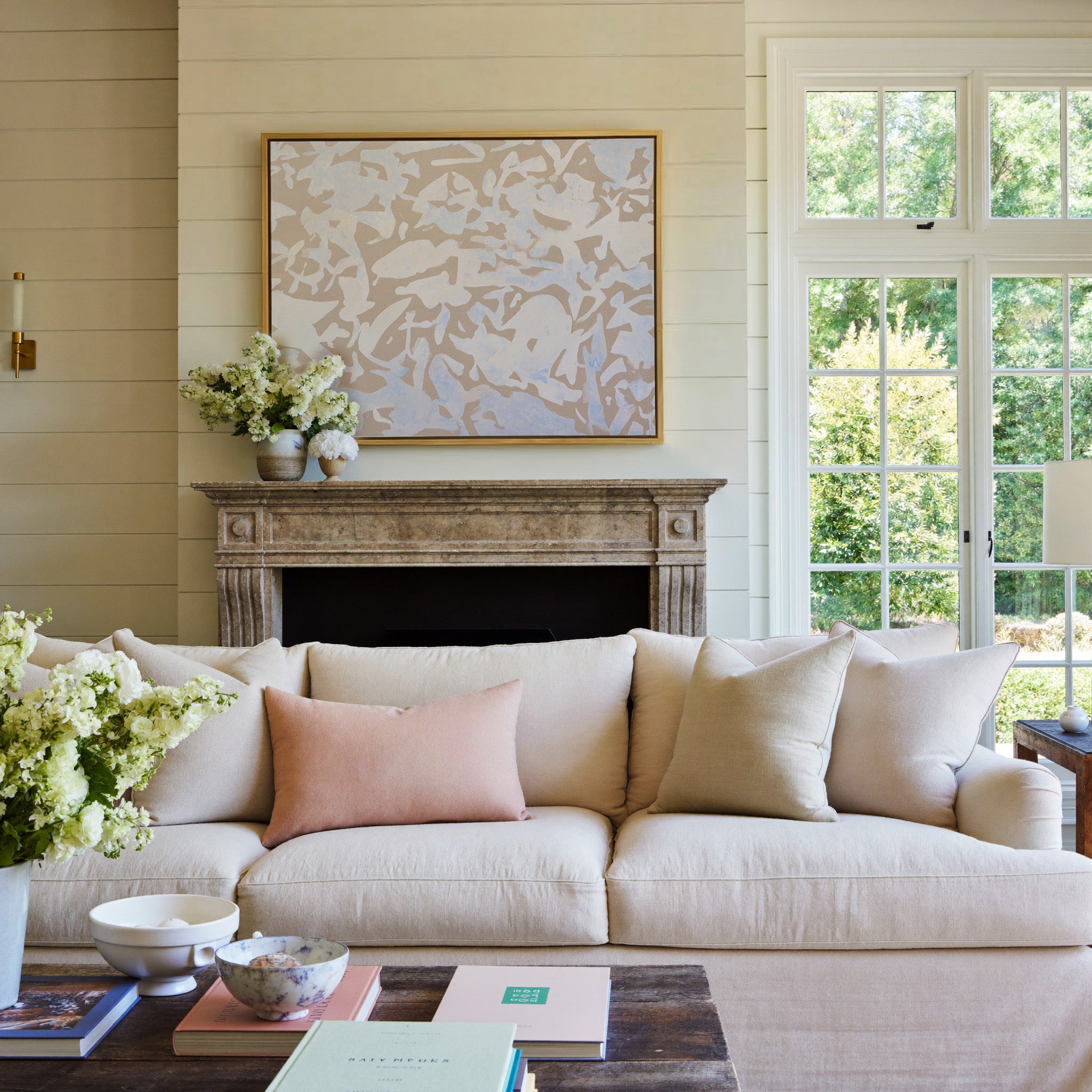 soft beige and pale blue abstract canvas wall art in a gold frame above a mantel