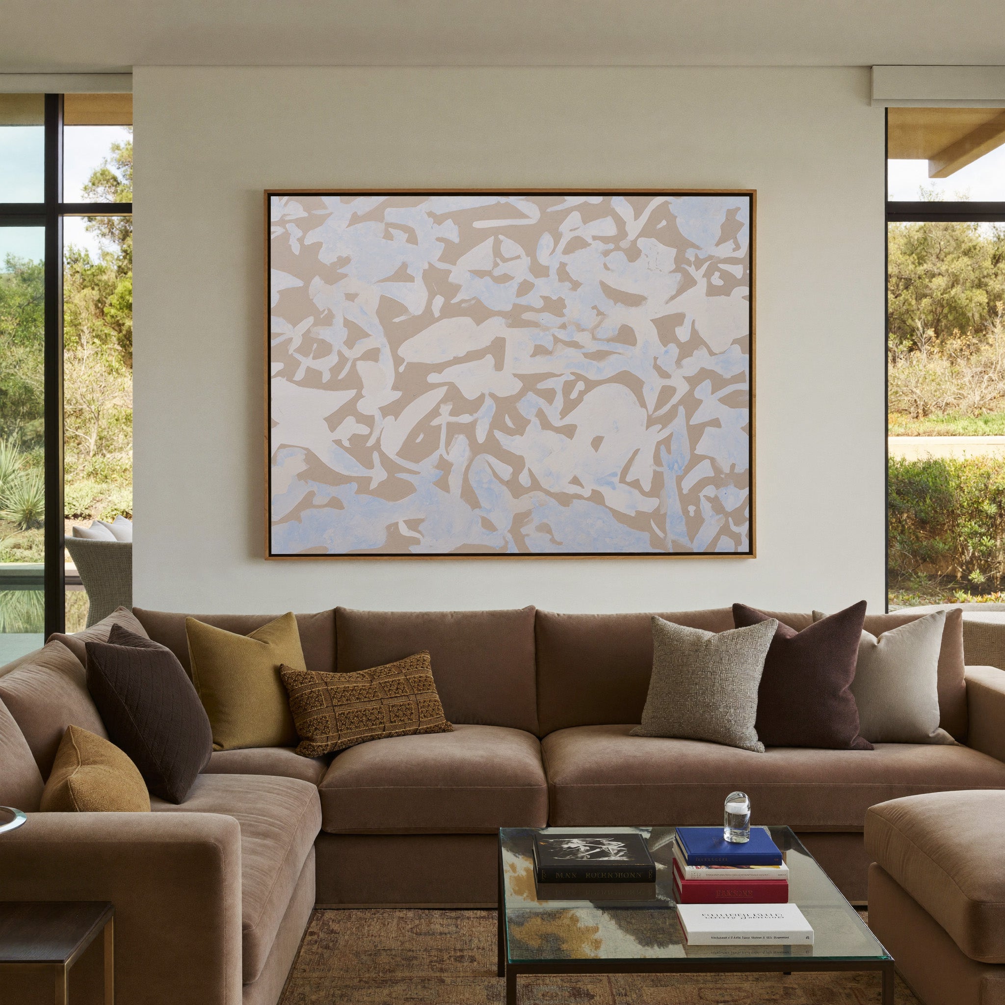 soft beige and pale blue abstract canvas wall art in an oak frame in a styled room setting