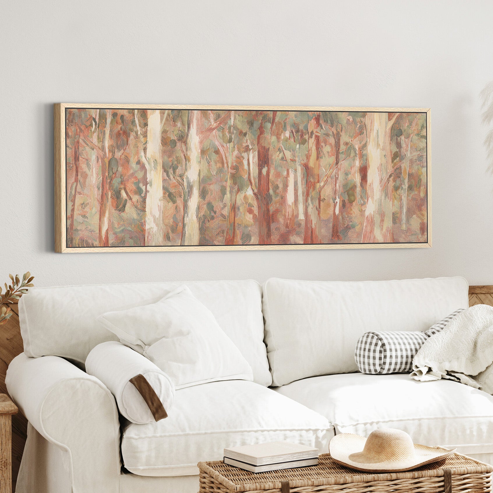soft eucalyptus forest with pale trunks and canvas wall art in an oak frame in a styled room setting