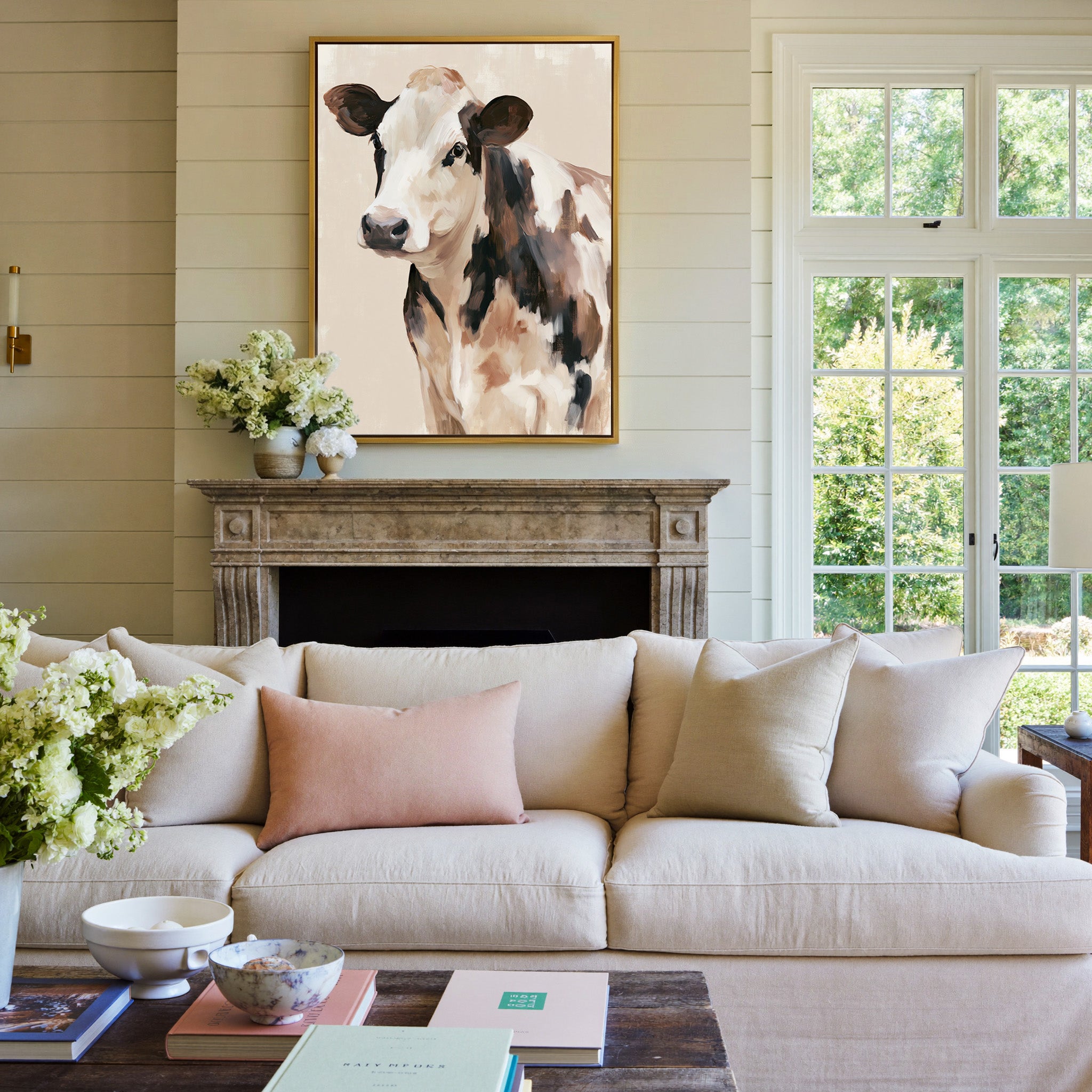 cream and brown cow portrait canvas wall art in a gold frame above a mantel