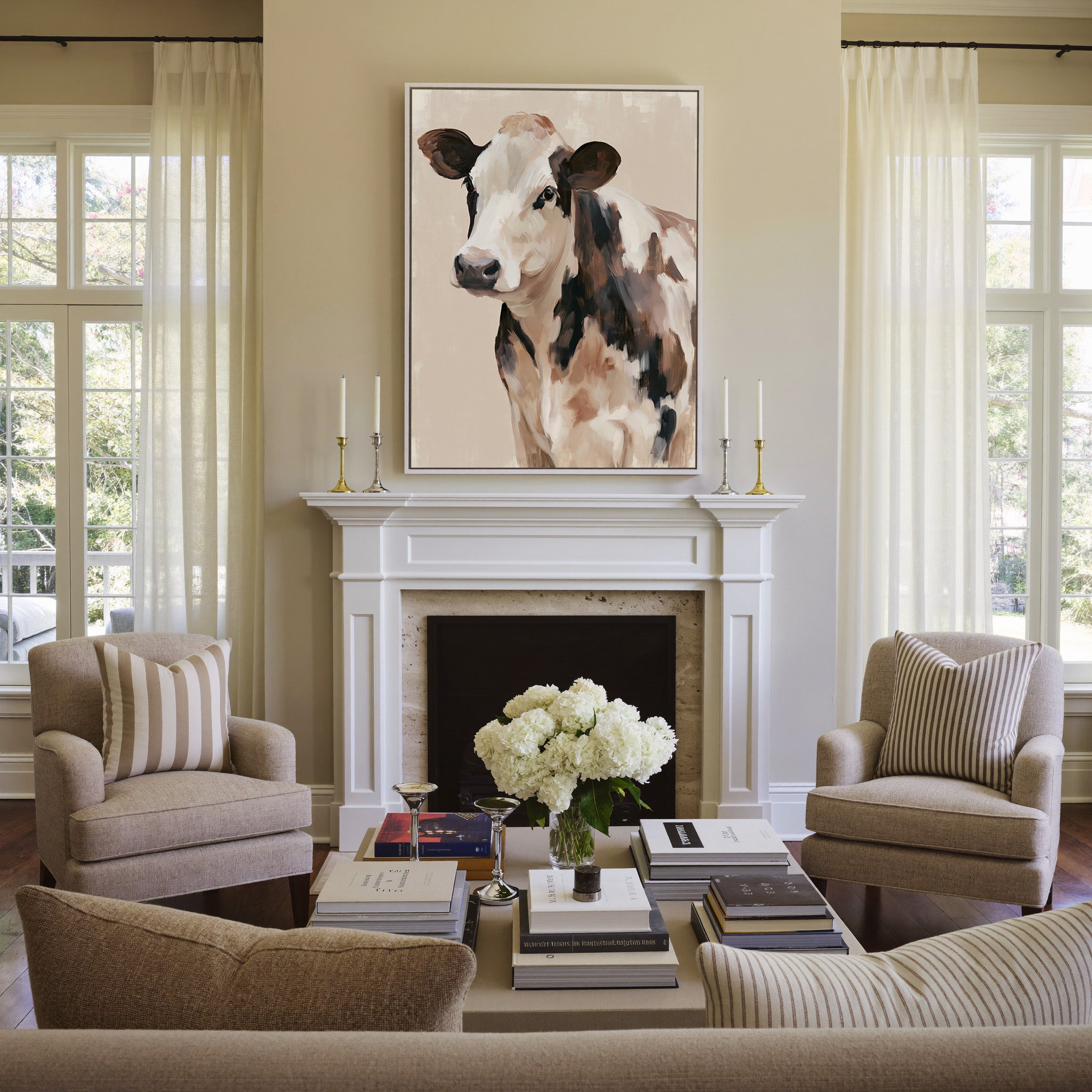 cream and brown cow portrait canvas wall art in a white frame above a mantel