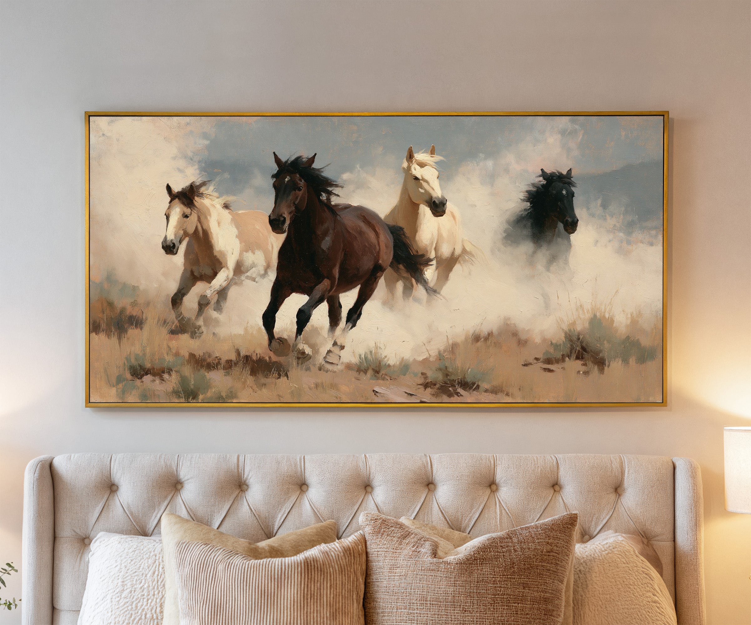 running horses in a dry open field with dust canvas wall art in a gold frame above a bed