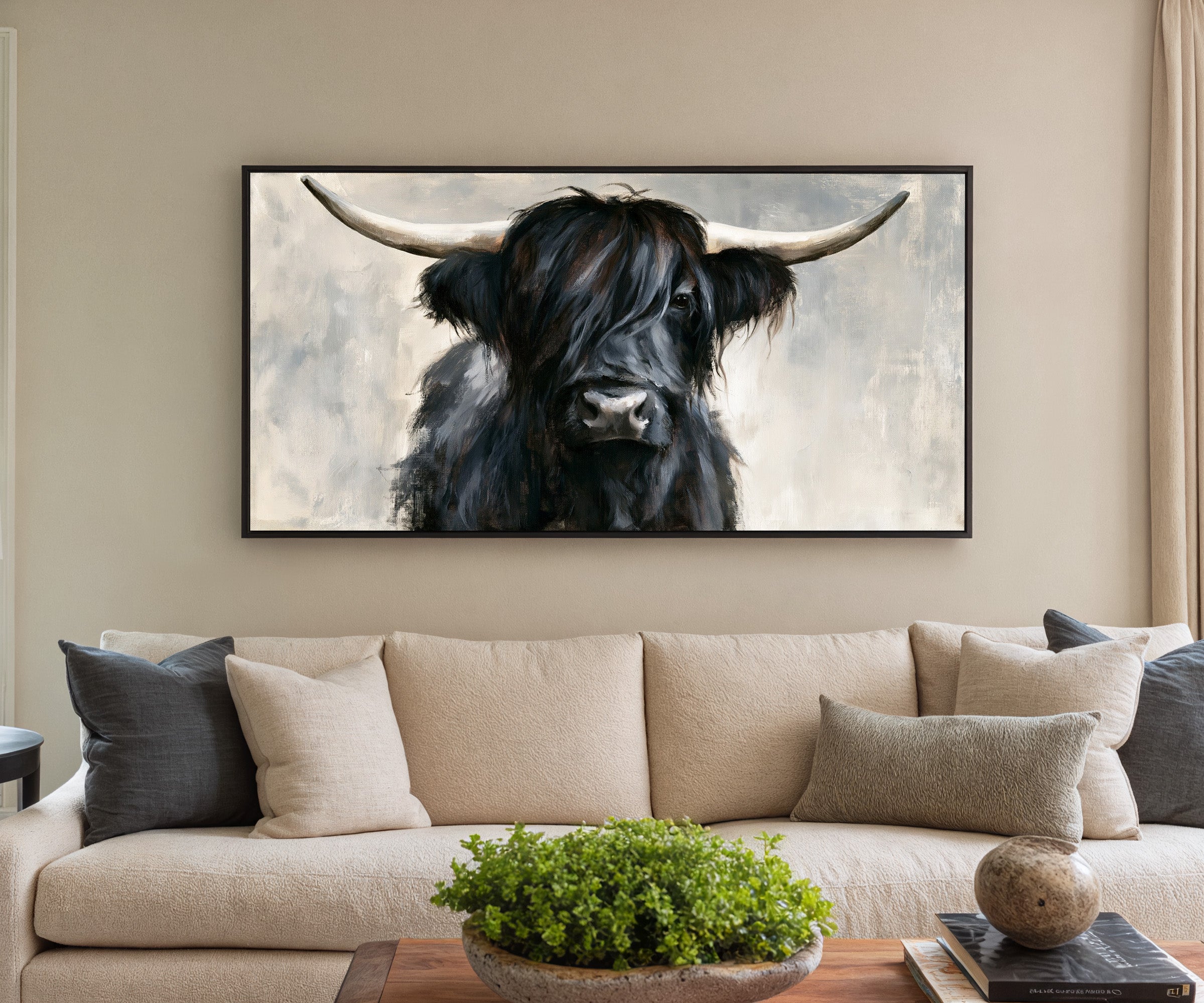 black highland cow with long shaggy hair and canvas wall art in a black frame in a styled room setting