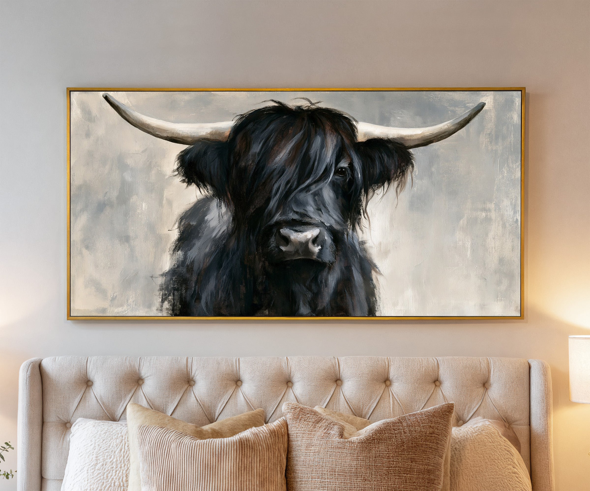 black highland cow with long shaggy hair and canvas wall art in a gold frame above a bed