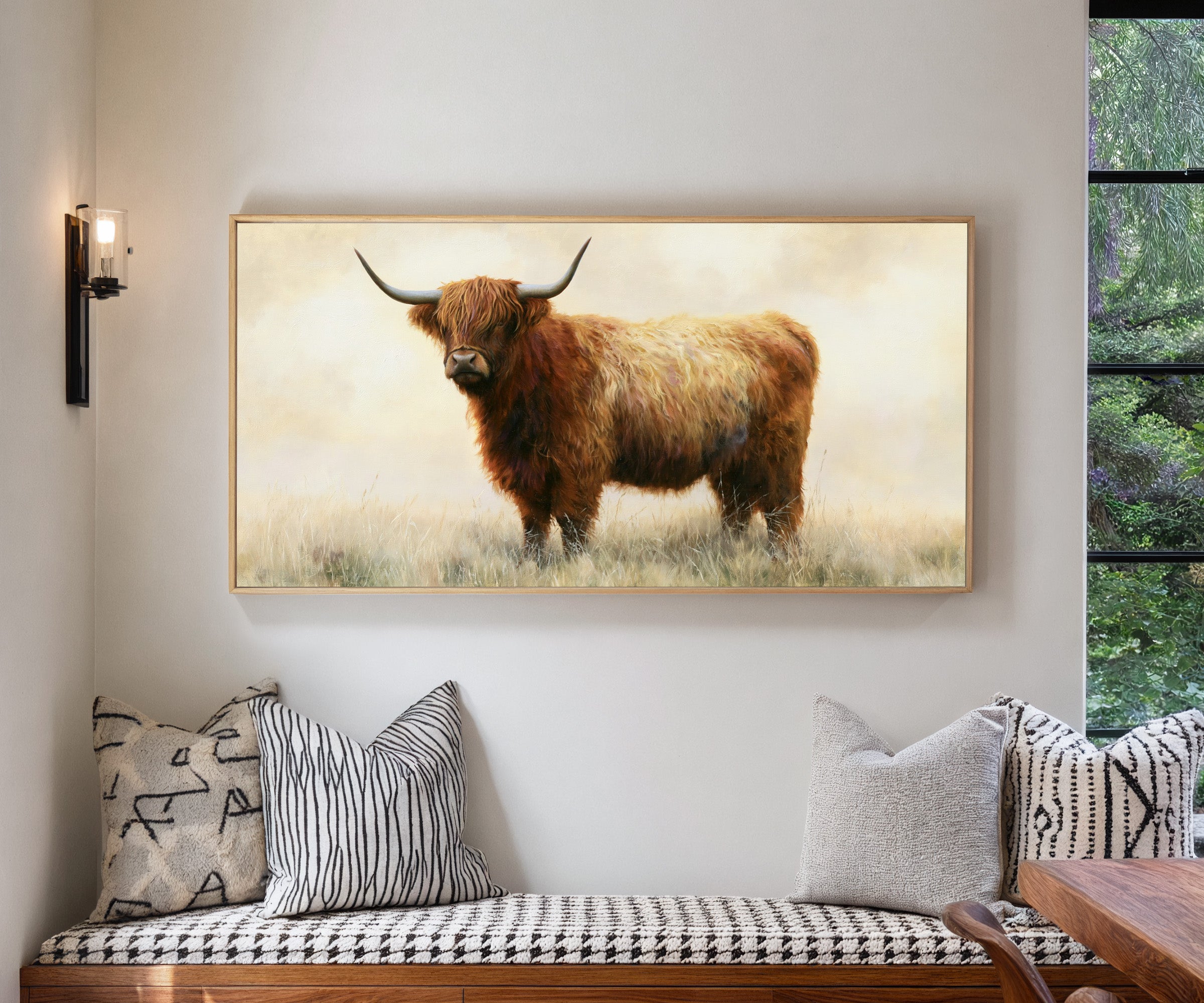 warm brown highland cow in pale dry grass canvas wall art in a natural wood frame in a living room