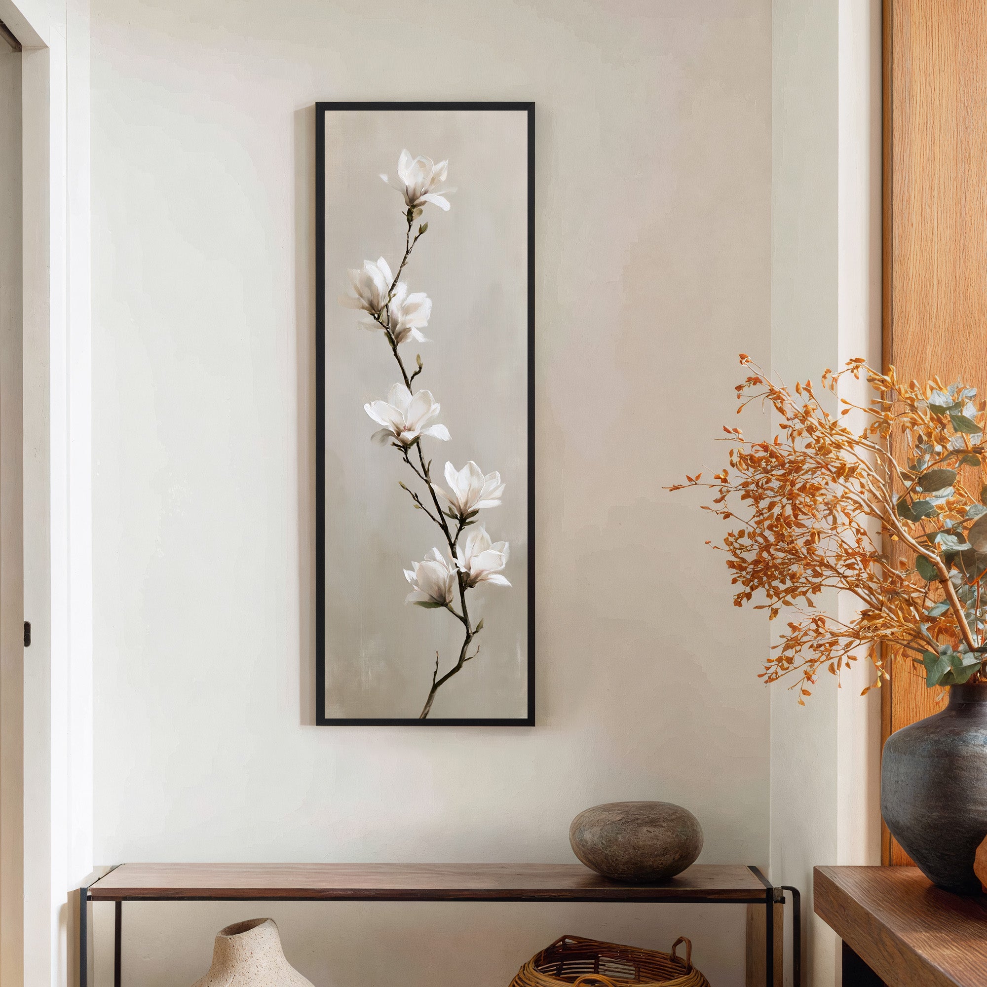 single white magnolia branch on a soft beige canvas wall art in a black frame in a styled room setting