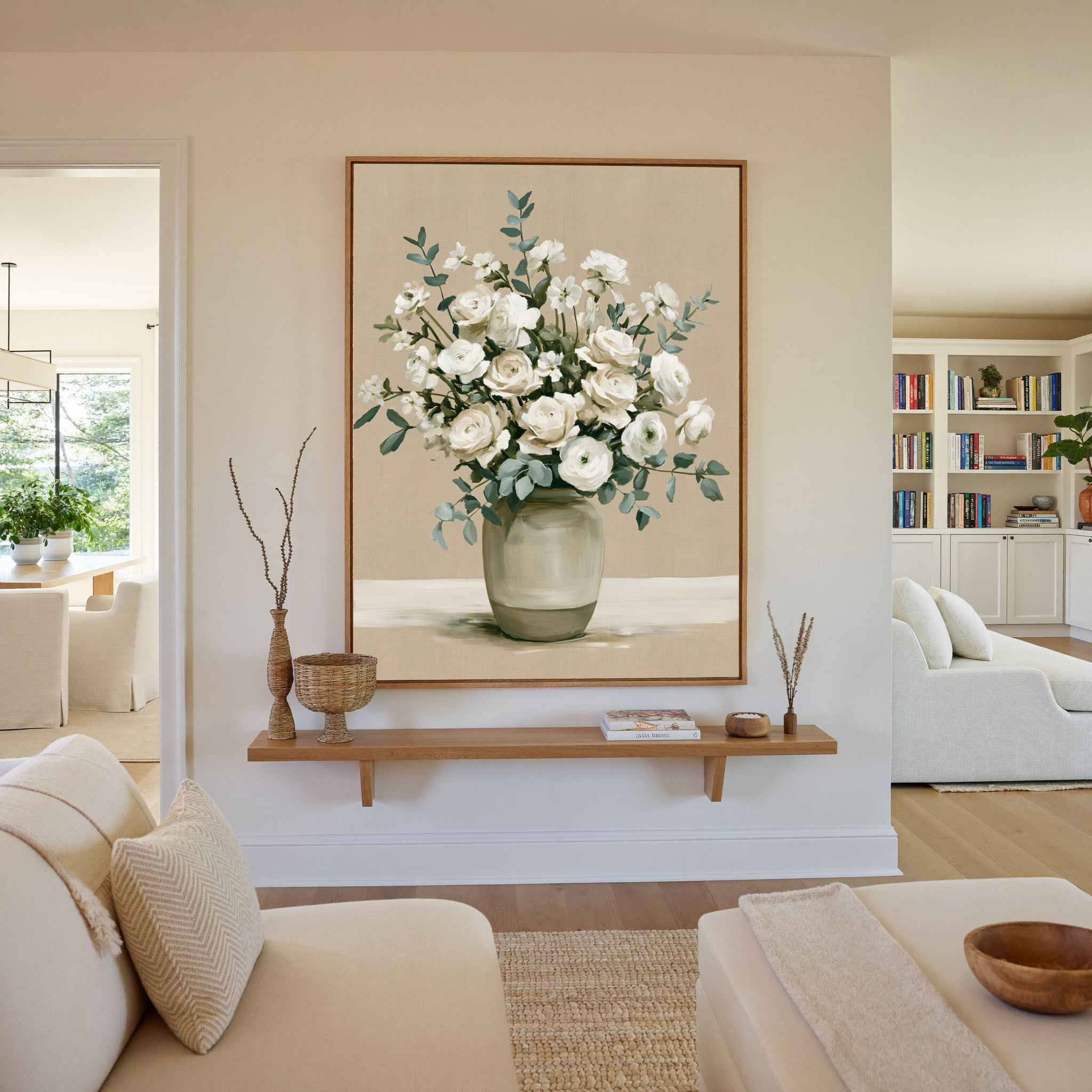 white roses and ranunculus in a glass vase canvas wall art in an oak frame in a living room