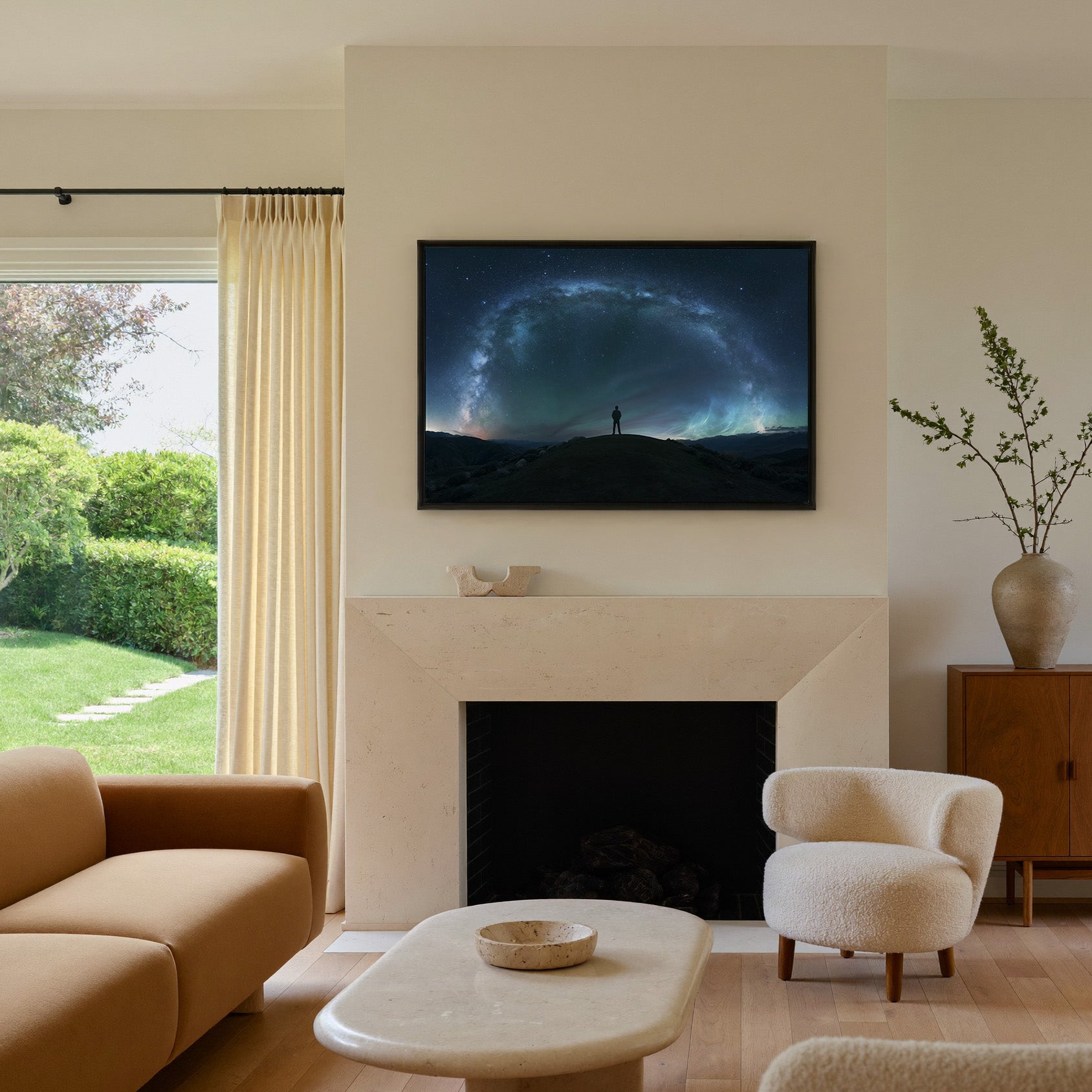 lone figure beneath a sweeping star arc canvas wall art in a black frame above a mantel