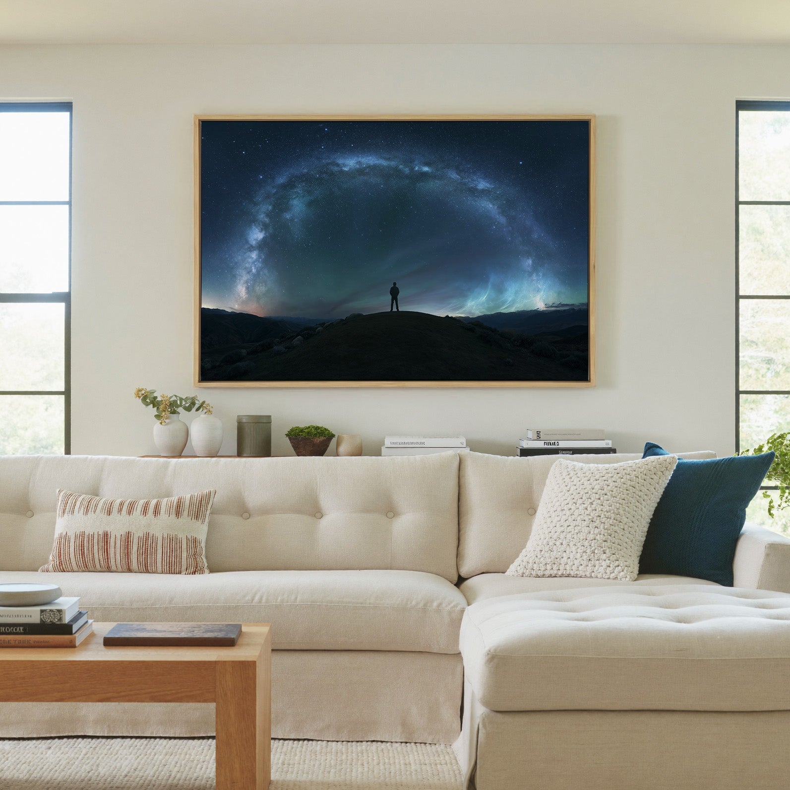 lone figure beneath a sweeping star arc canvas wall art in a natural wood frame in a living room