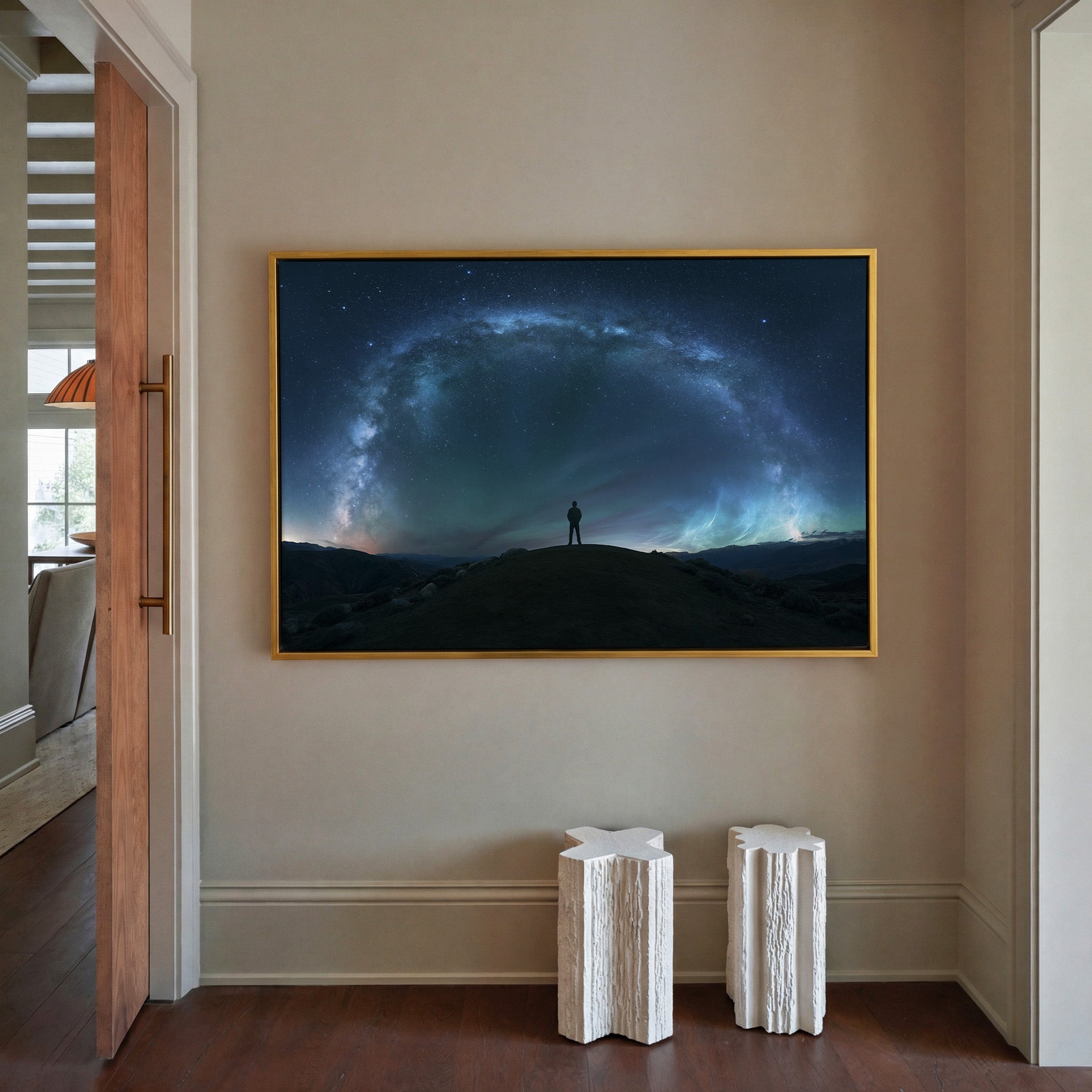 lone figure beneath a sweeping star arc canvas wall art in a gold frame in a styled room setting