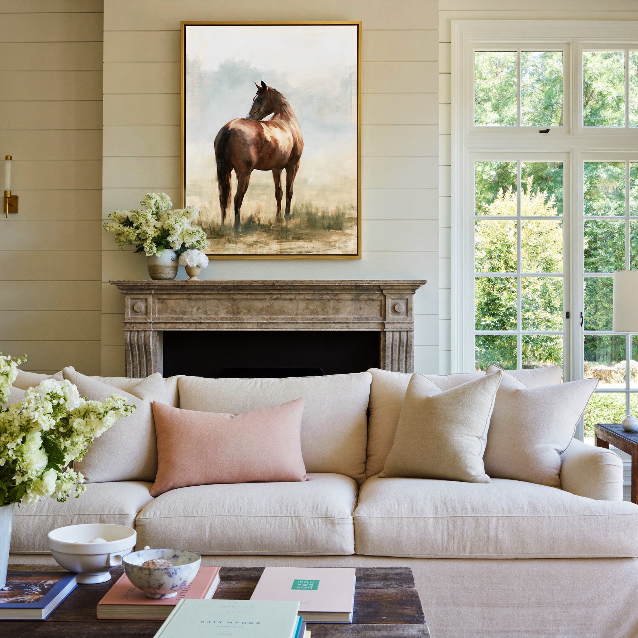 single chestnut horse in a pale open field canvas wall art in a gold frame above a mantel