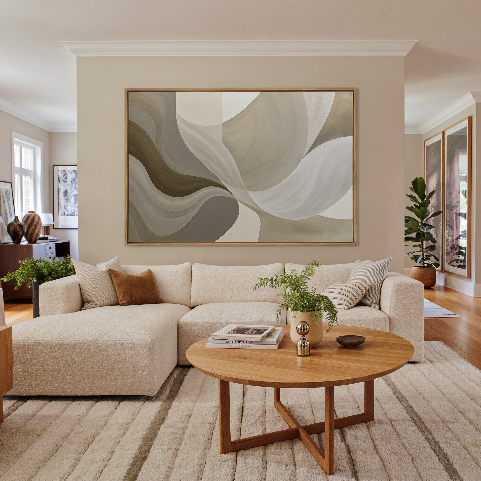neutral abstract with large sweeping cream, canvas wall art in an oak frame in a living room