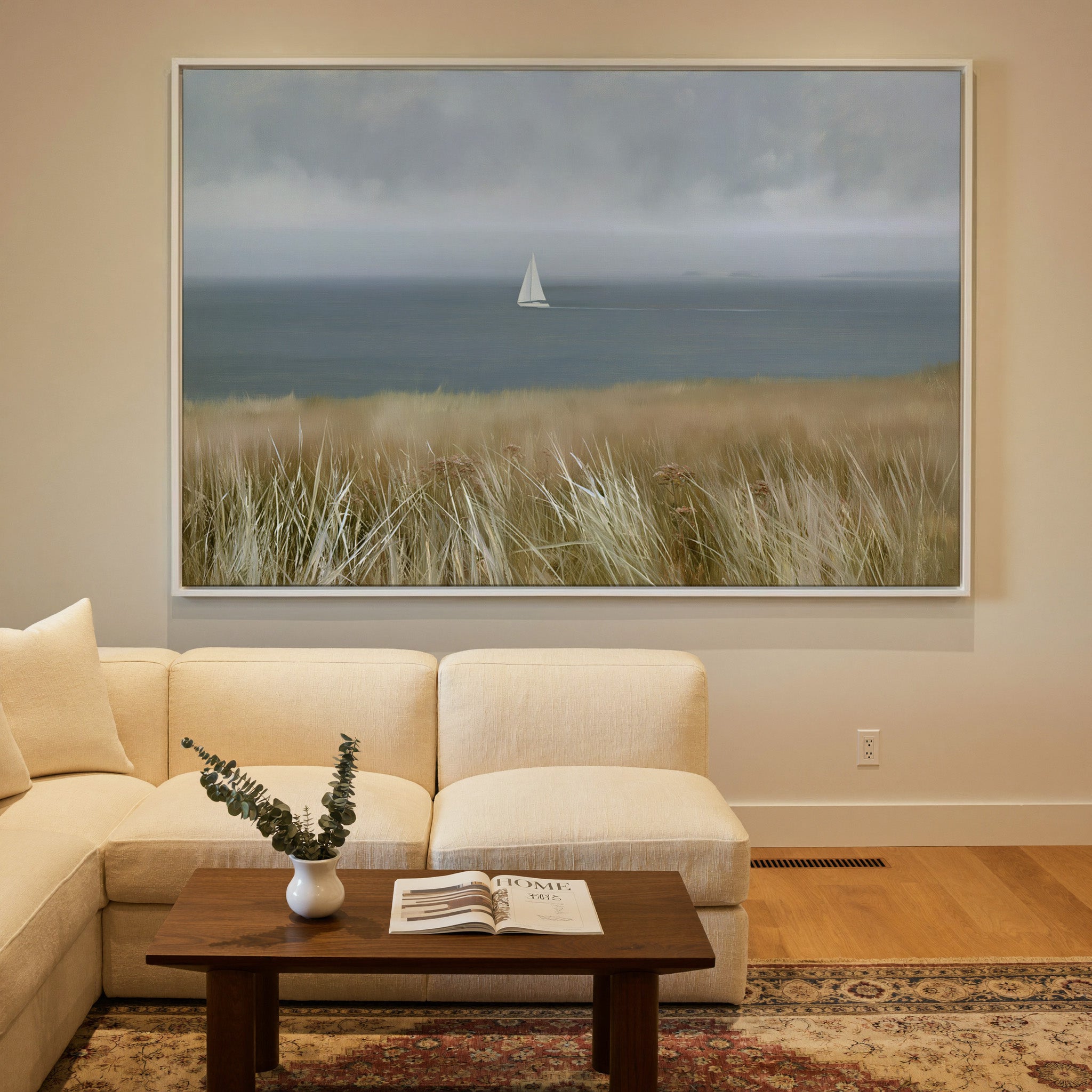 distant white sailboat on a gray blue sea canvas wall art in a white frame in a styled room setting