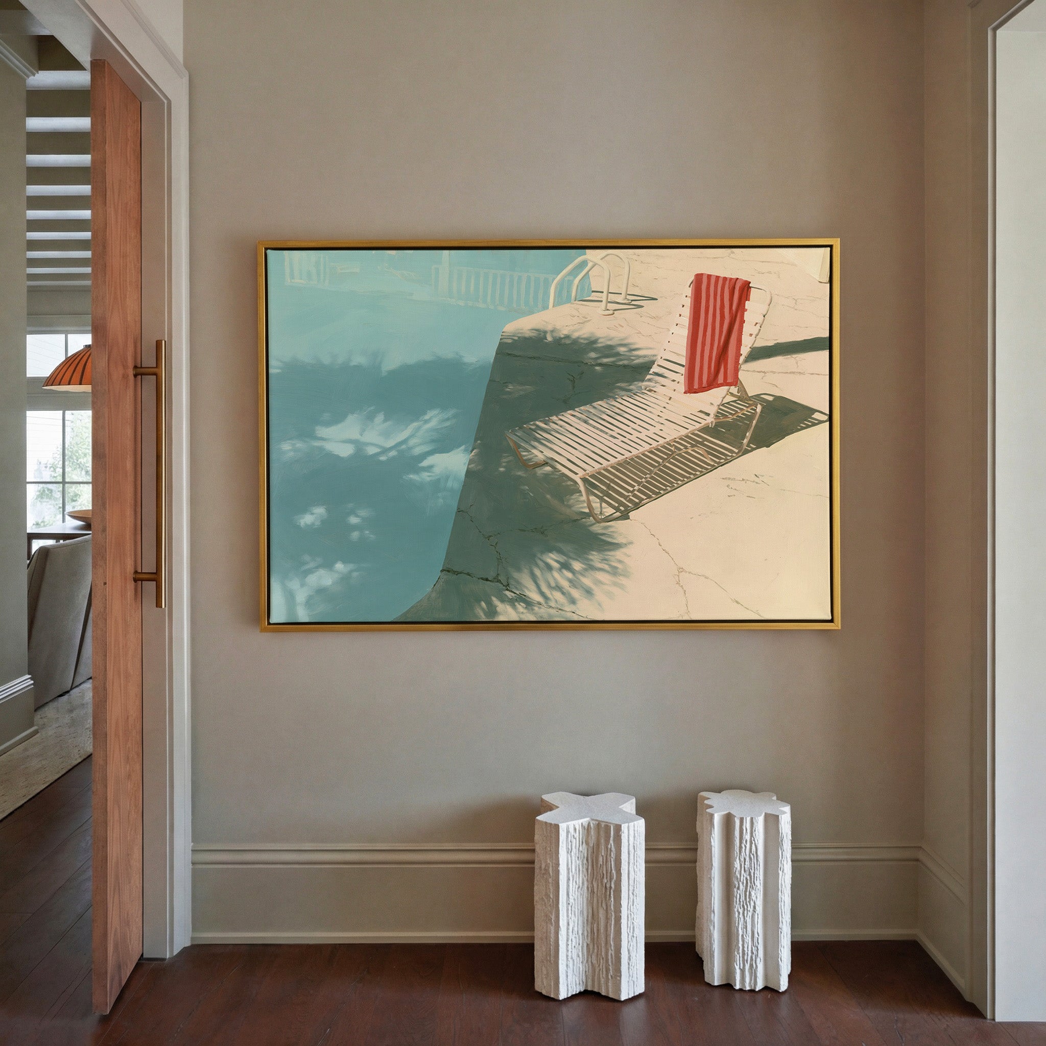sunlit turquoise pool with striped lounge chair canvas wall art in a gold frame in a styled room setting