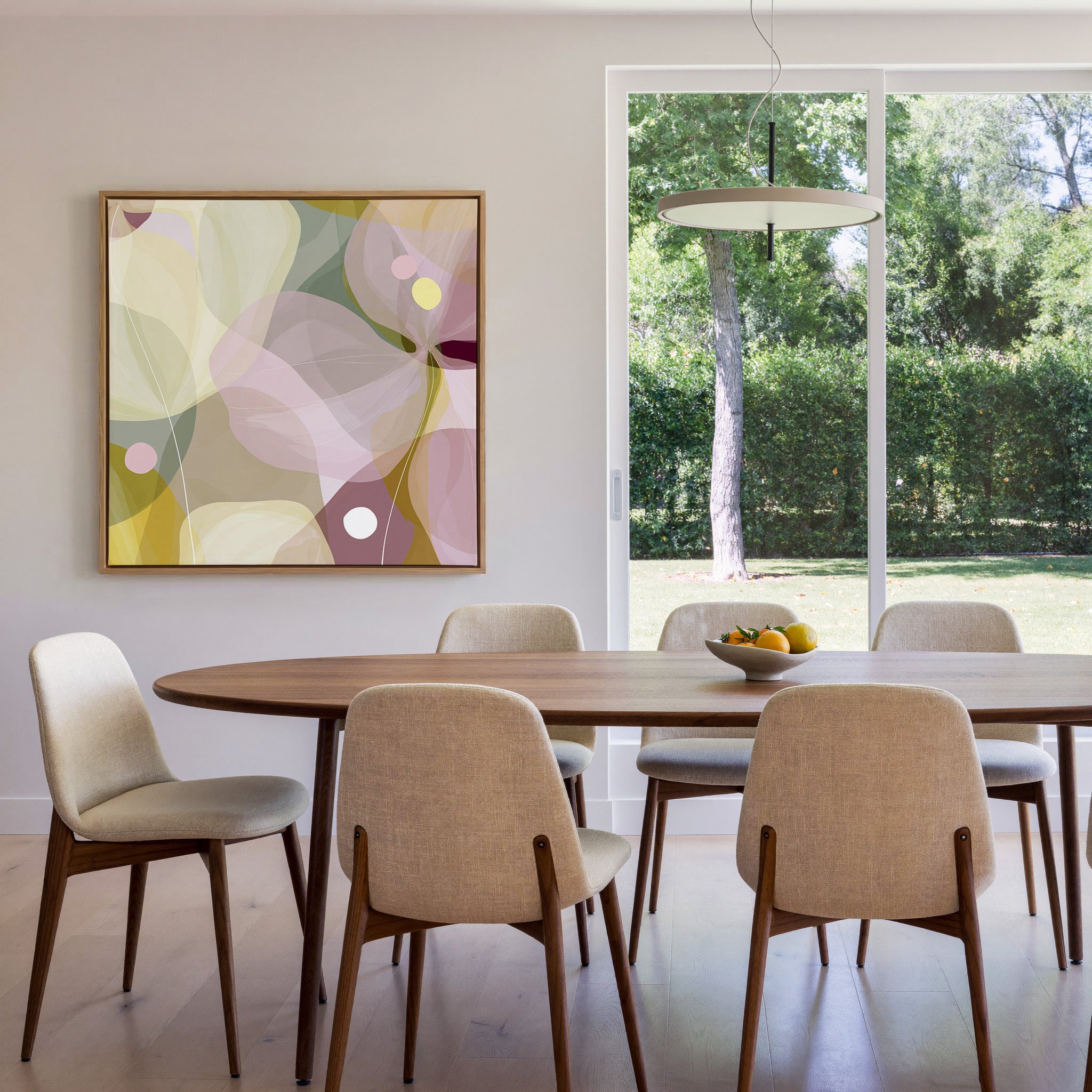 soft translucent petals in blush, cream, and canvas wall art in an oak frame in a dining room