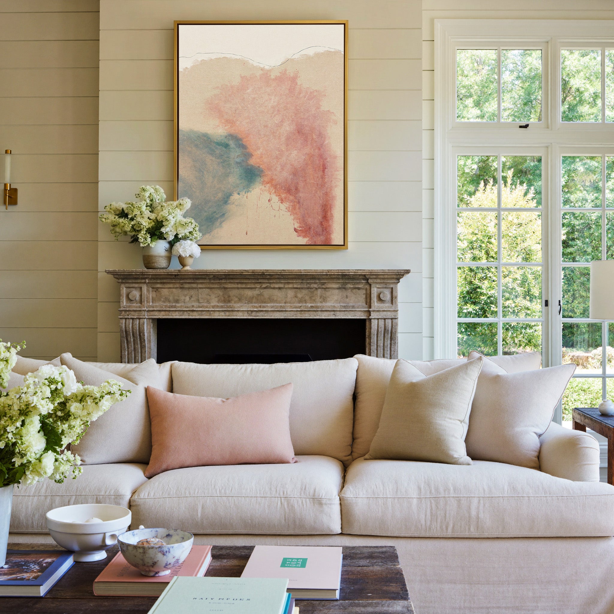 blush pink and teal abstract with soft clouded canvas wall art in a gold frame above a mantel