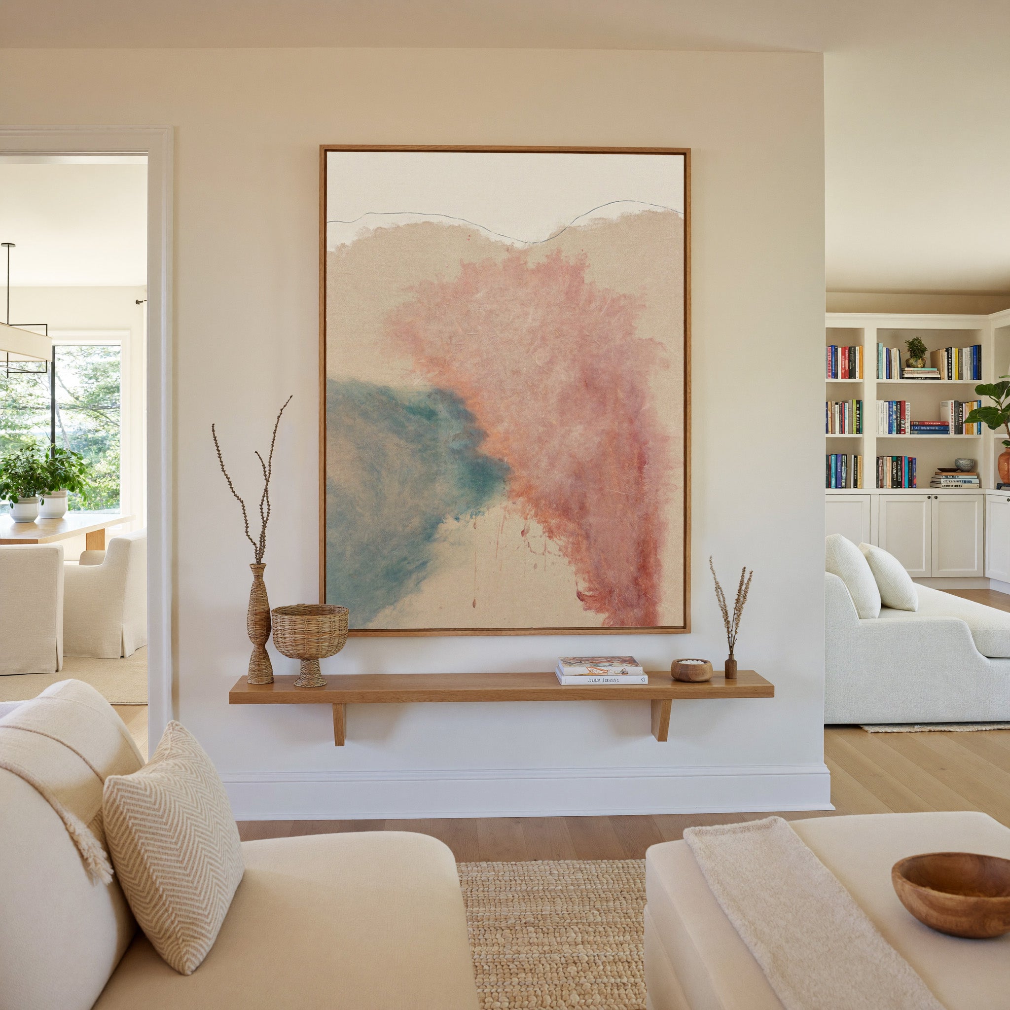 blush pink and teal abstract with soft clouded canvas wall art in an oak frame in a living room