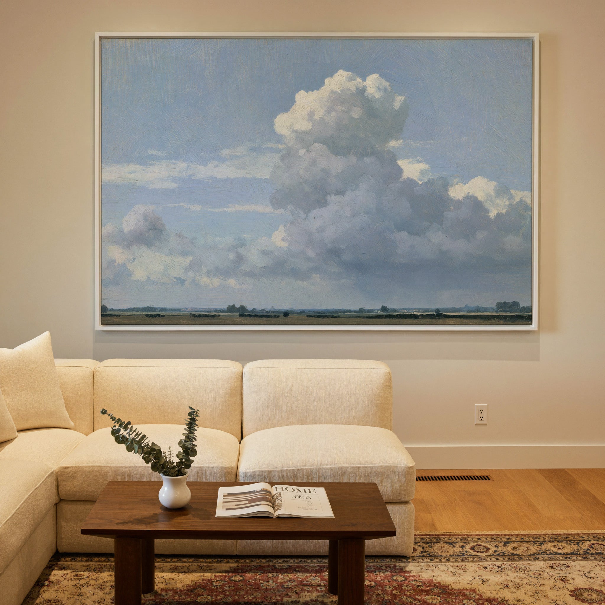 vast blue sky with towering white cloud over a canvas wall art in a white frame in a styled room setting