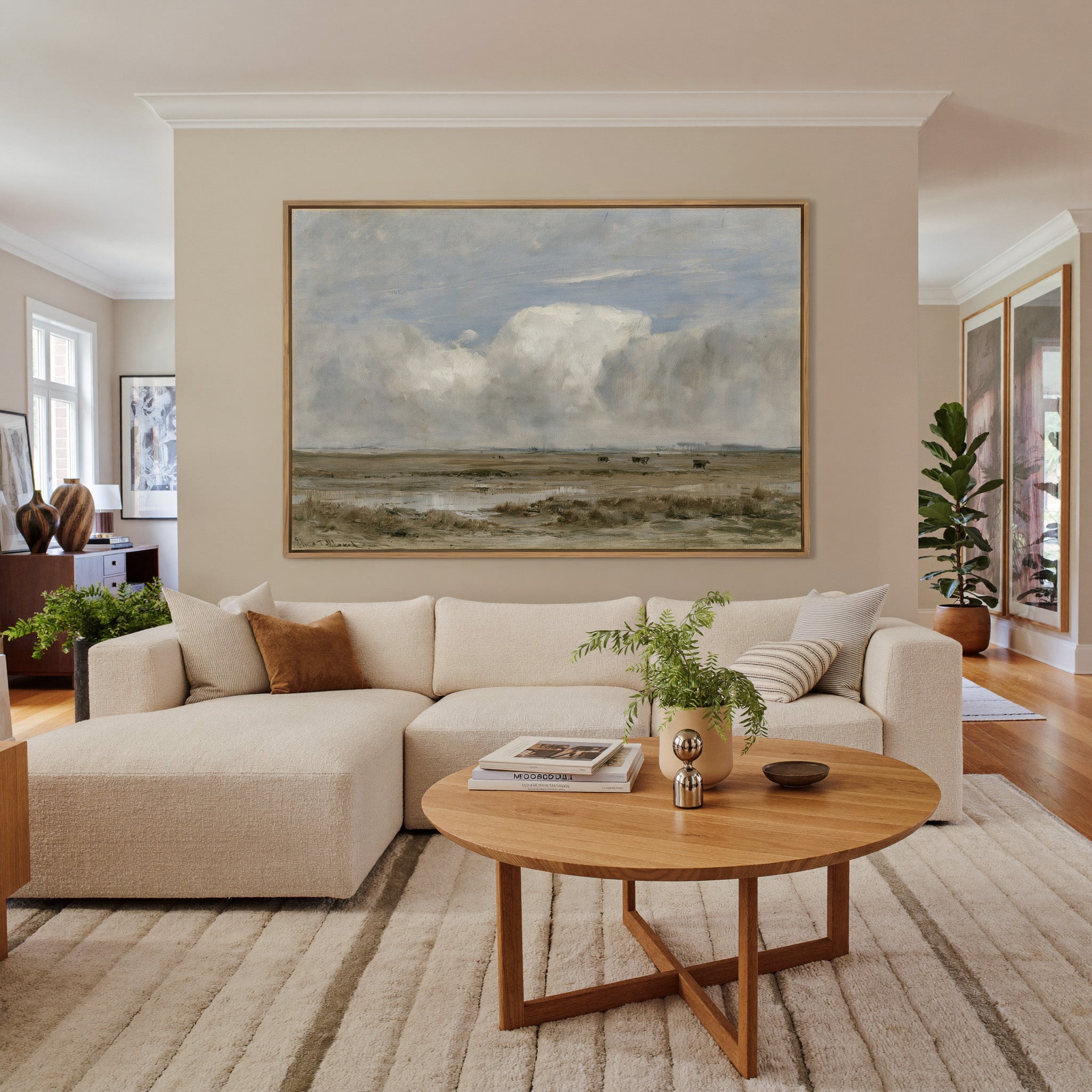 pale countryside with wet fields and a broad canvas wall art in an oak frame in a living room