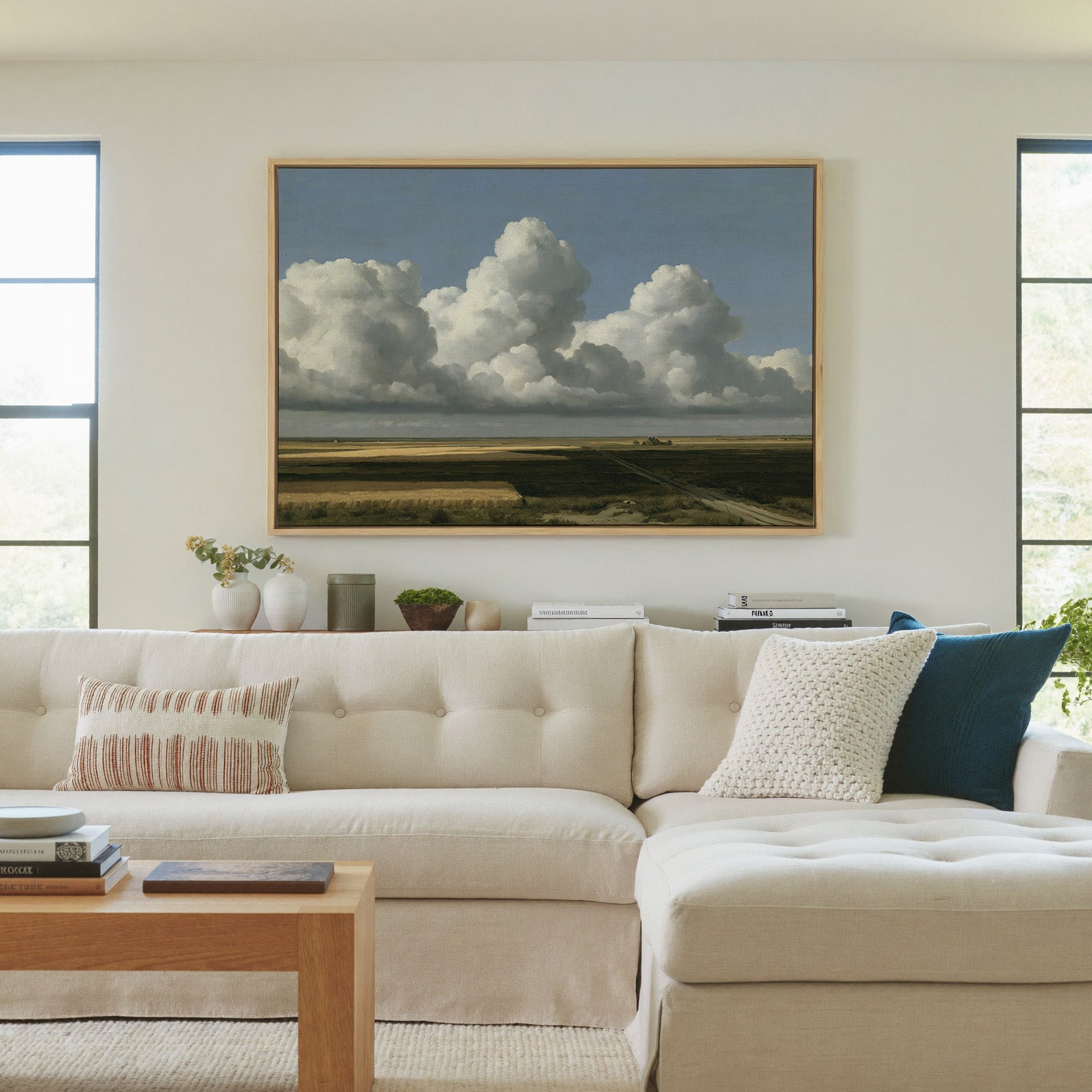 vast blue sky over low patchwork fields canvas wall art in a natural wood frame in a living room